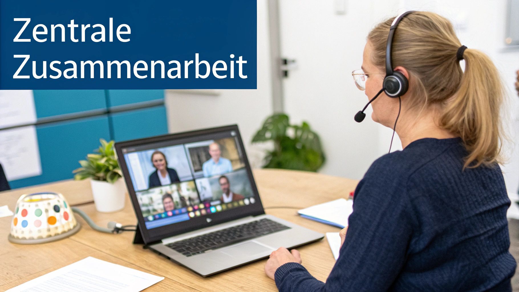 Eine Frau mit Headset sitzt am Tisch und nimmt an einer Videokonferenz auf ihrem Laptop teil, mit dem Text 'Zentrale Zusammenarbeit'.