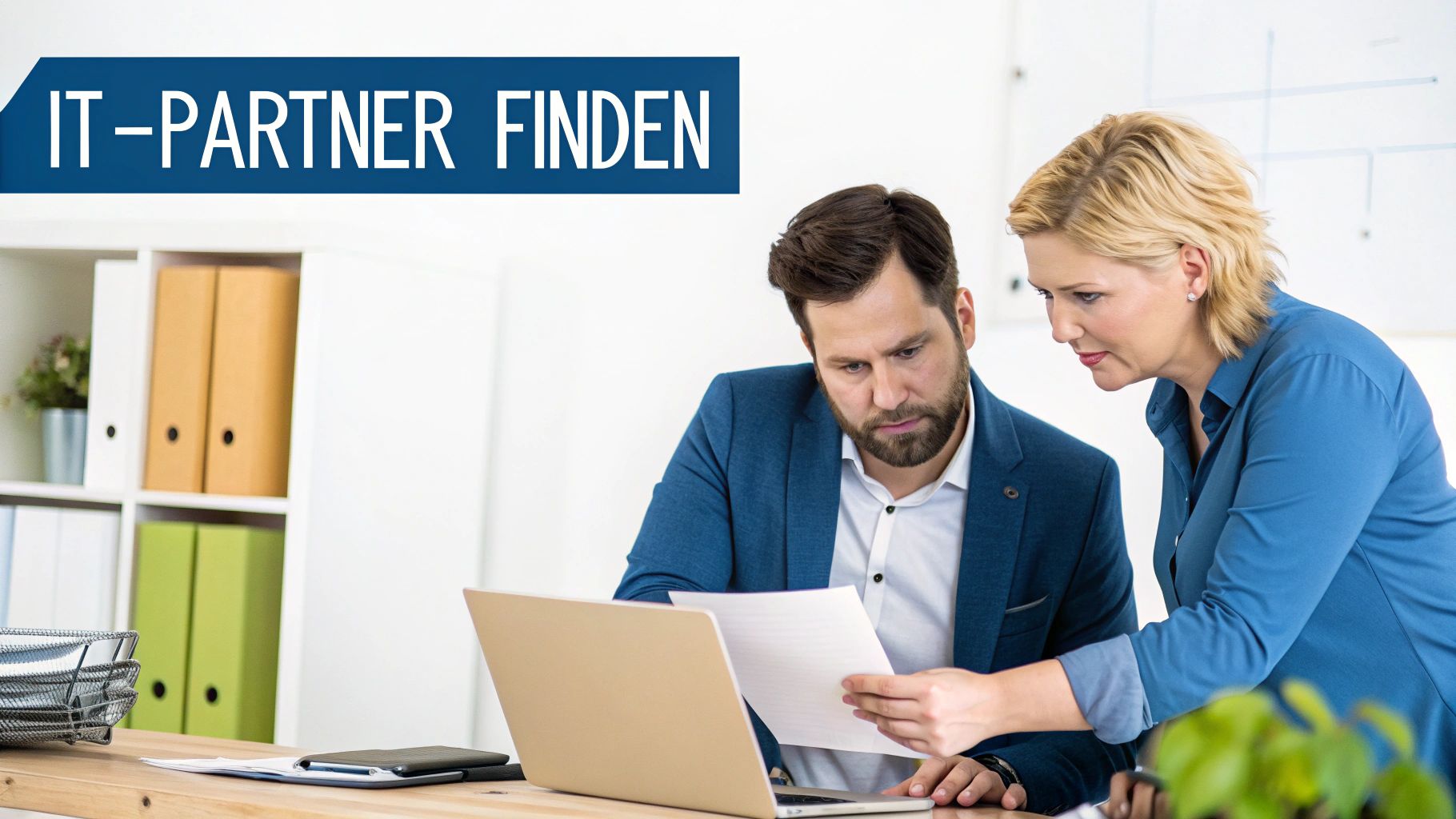 Zwei Business-Profis, ein Mann und eine Frau, besprechen IT-Lösungen an einem Laptop im Büro.