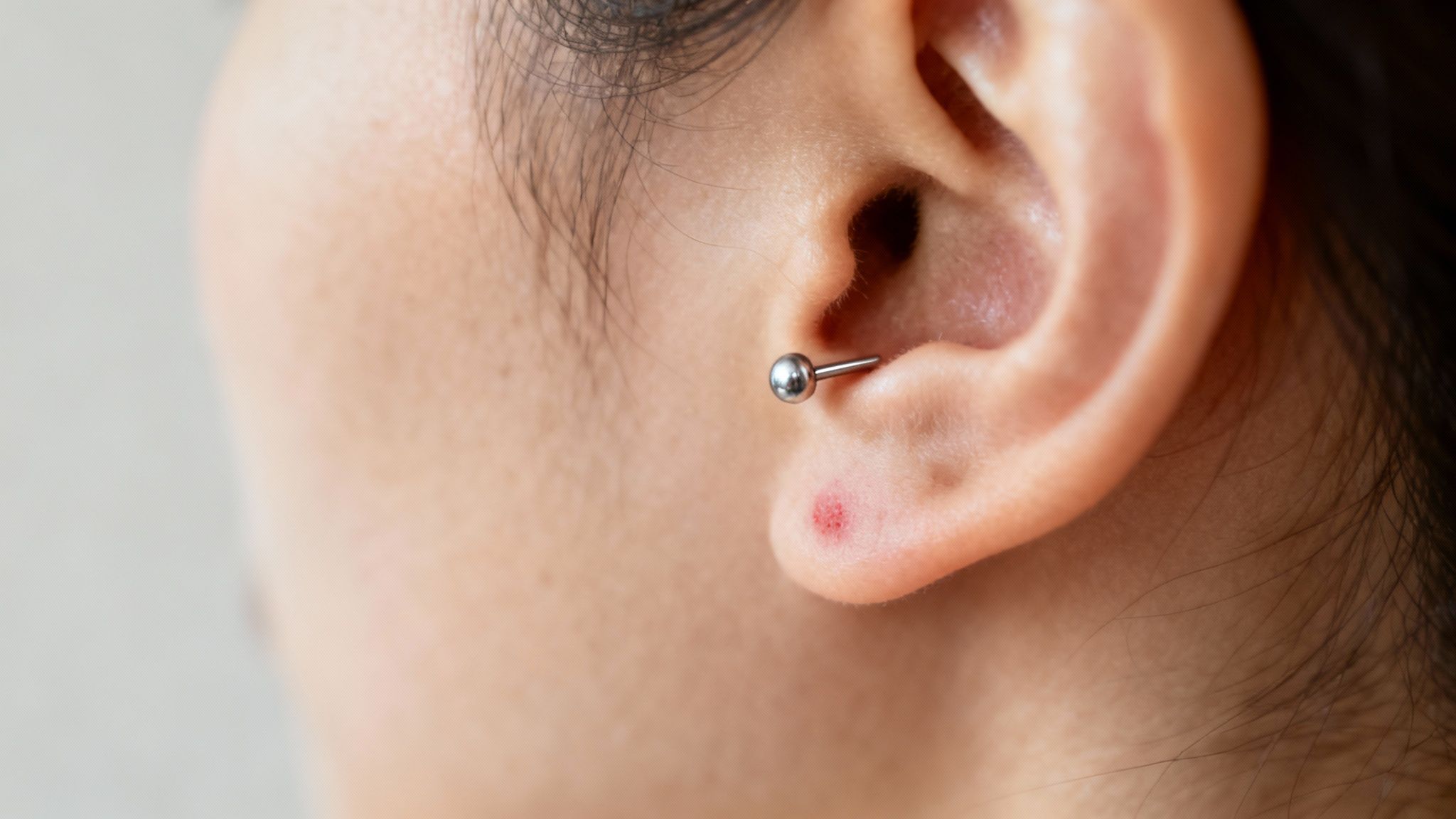 A person wearing elegant, nickel-free silver earrings and a necklace, touching their neck gently without any sign of irritation.