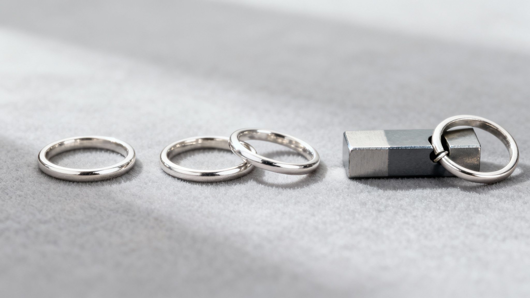 A close-up of a white gold ring being tested with a small magnet.