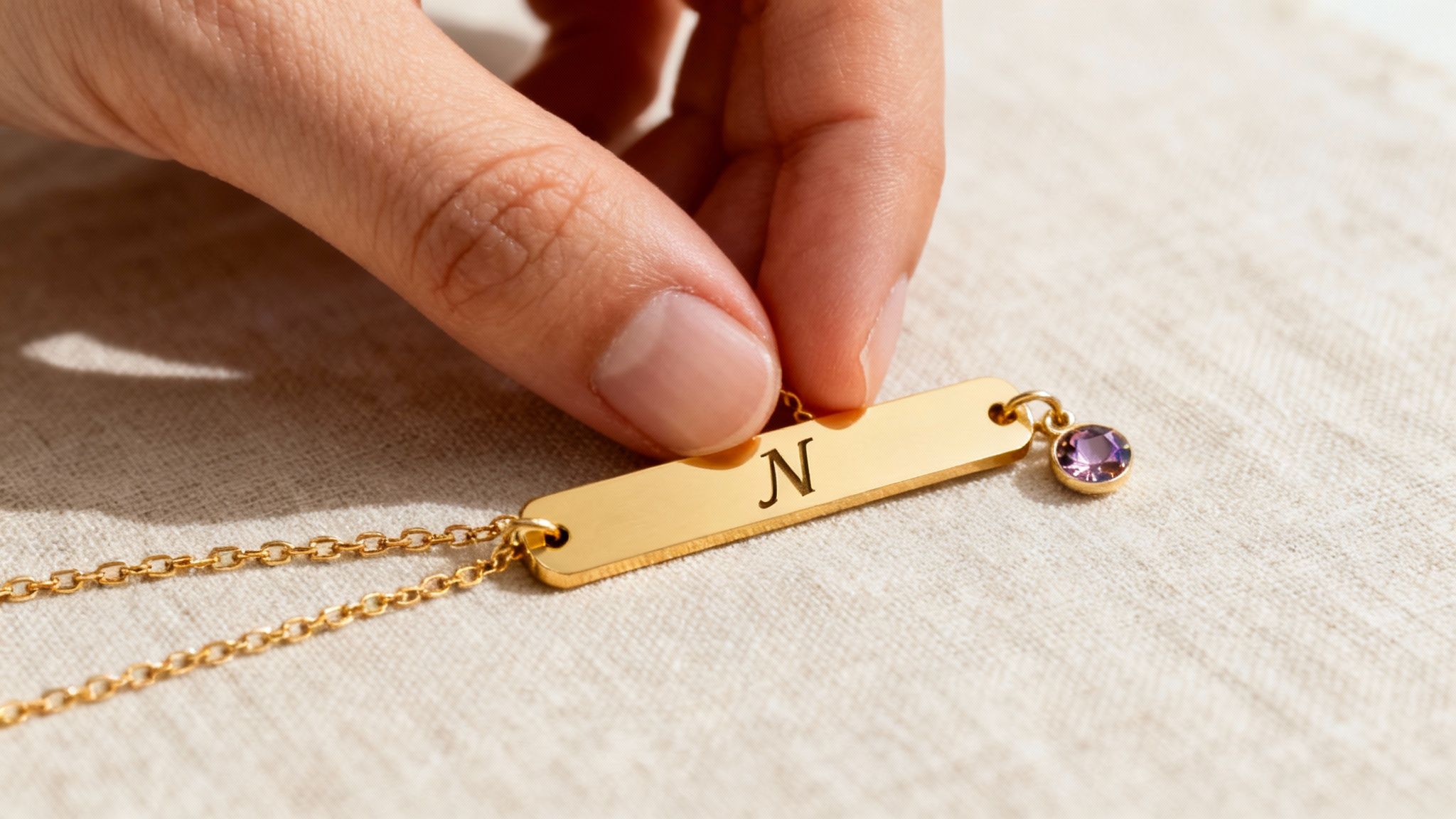 A personalized locket necklace being held, with a blurred festive background.