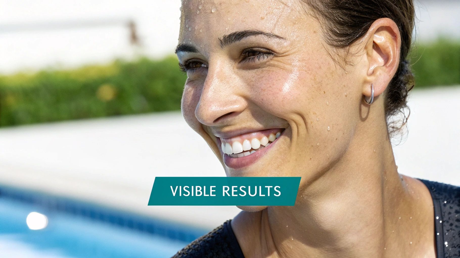 Smiling woman with glowing, dewy skin and water droplets, showing positive results.