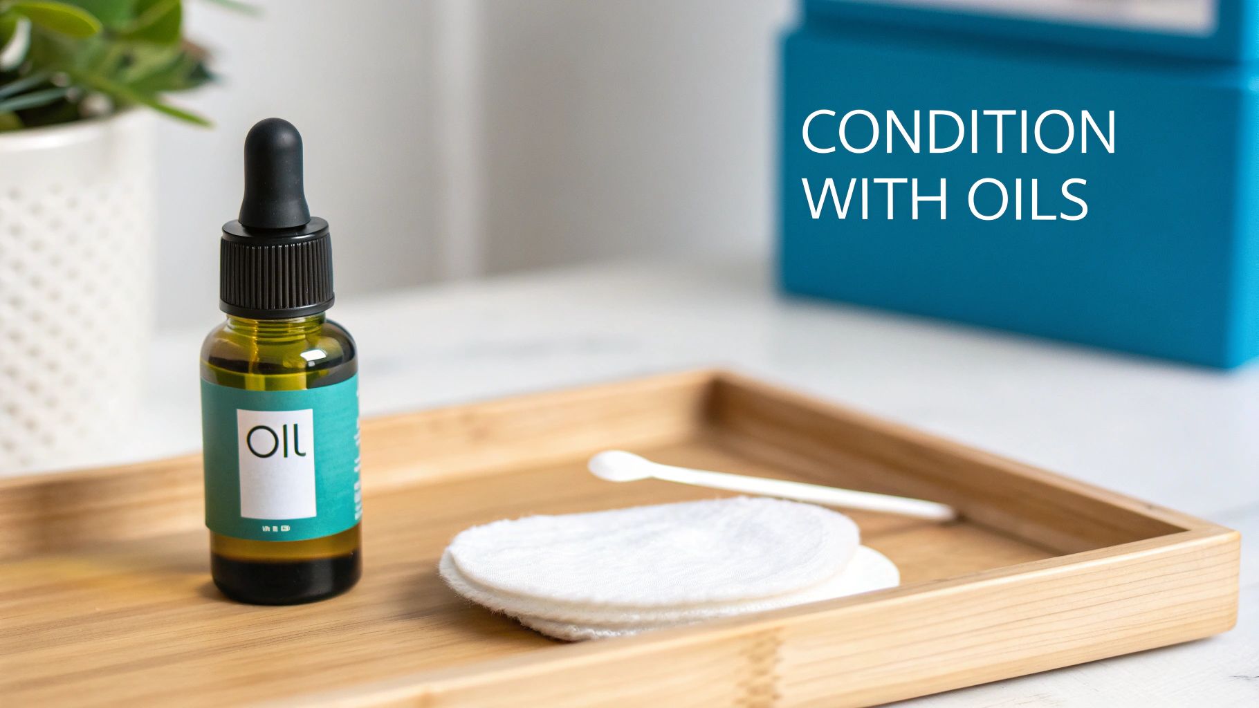 A dropper bottle of oil, cotton pads, and a scoop on a wooden tray with "CONDITION WITH OILS" text.
