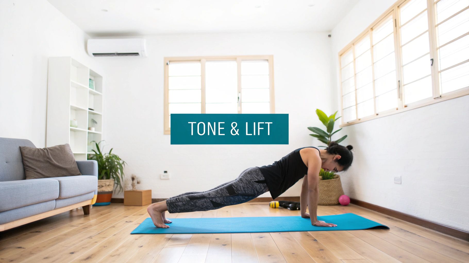 Woman in a black top doing a plank exercise on a blue yoga mat at home.