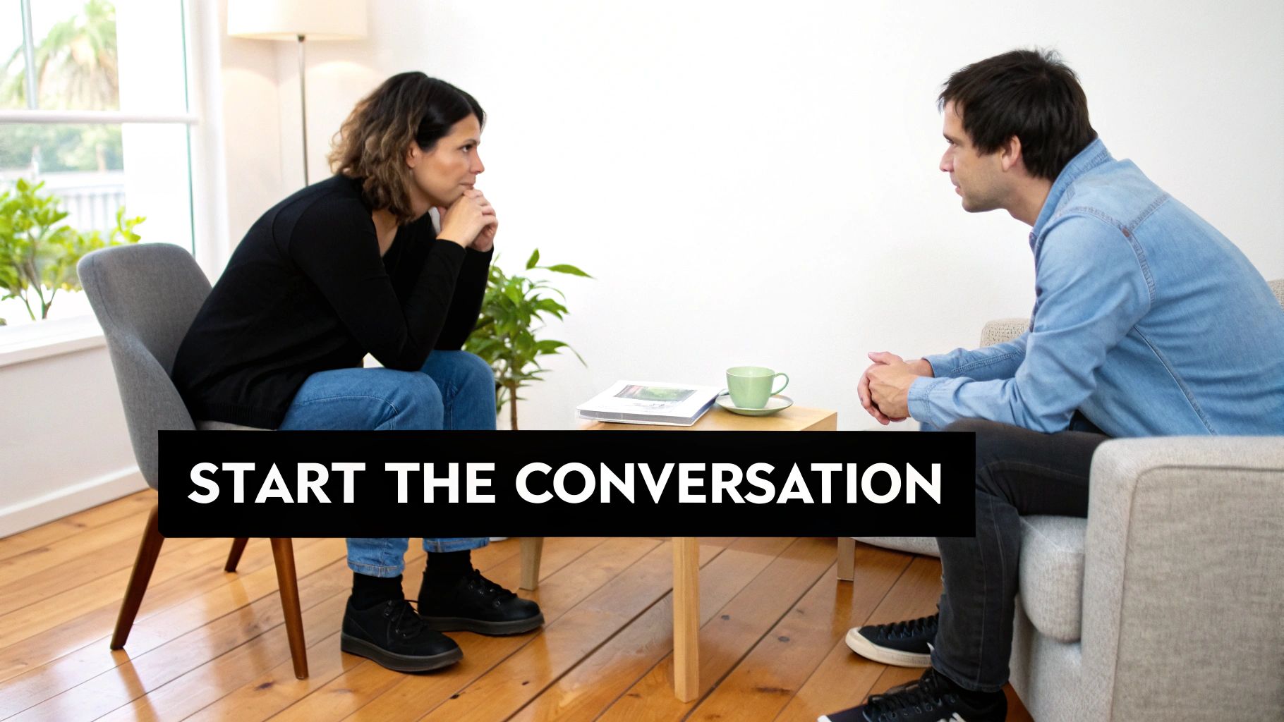 Two people, a woman and a man, sit facing each other, engaged in a serious conversation.