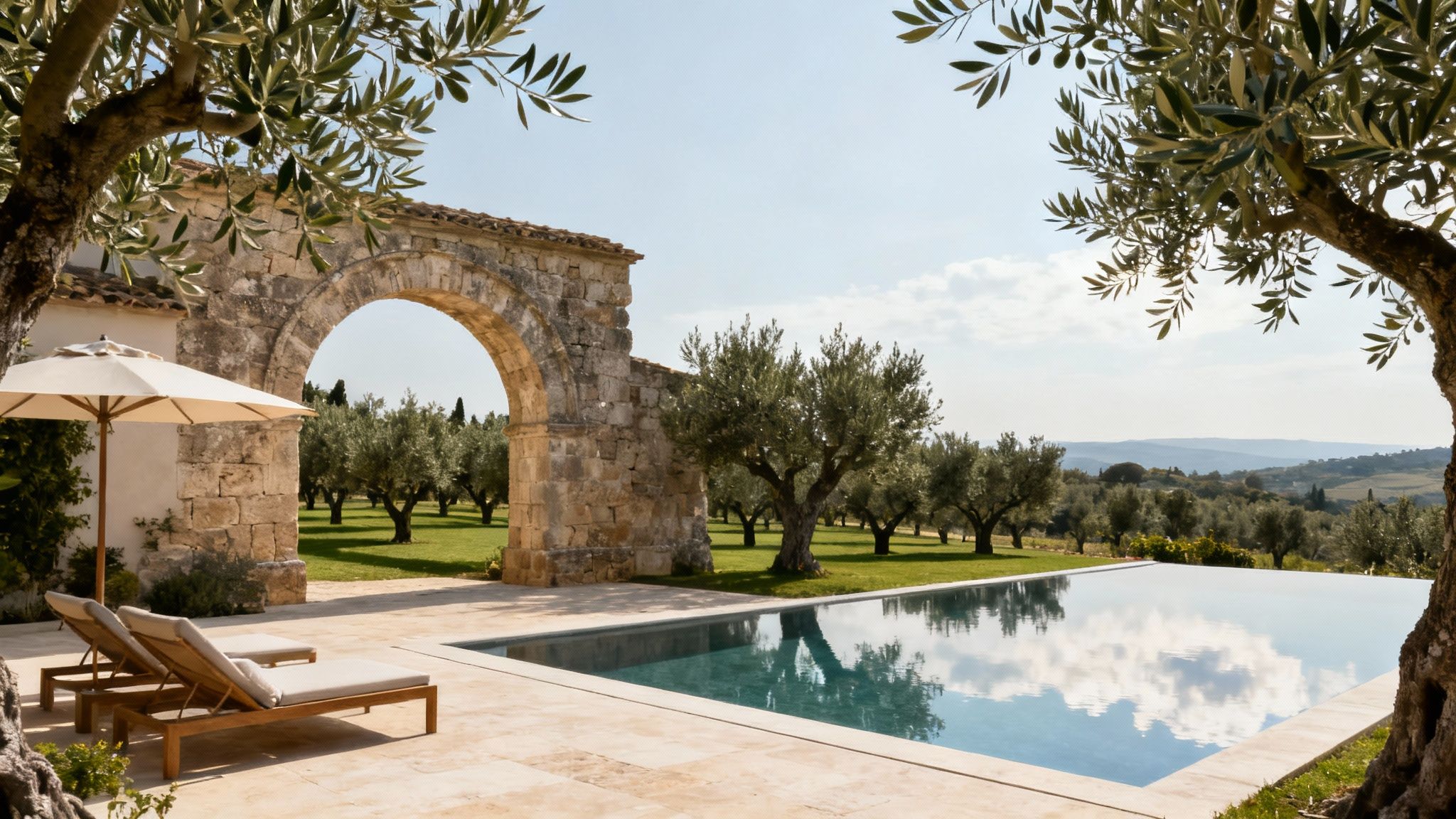 A serene infinity pool at a Le Collectionist villa in Italy, overlooking rolling hills and a clear blue sky.