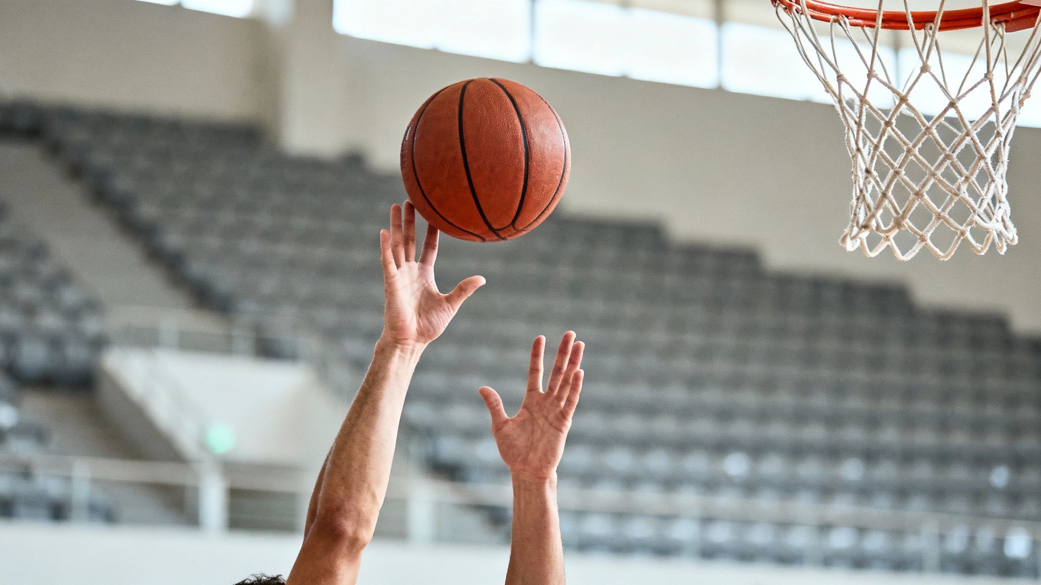 A basketball player executing a powerful defensive block near the rim during a game.