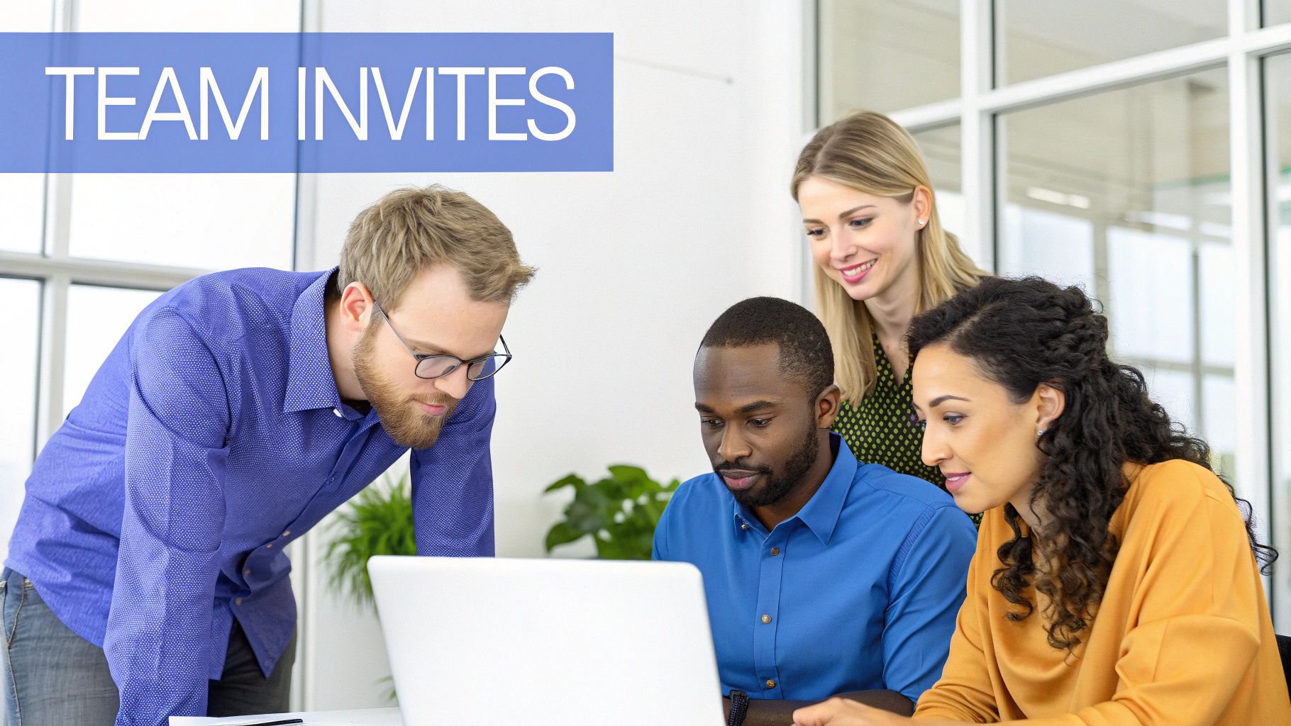 A diverse team of four people looking at a laptop, collaborating in an office setting.