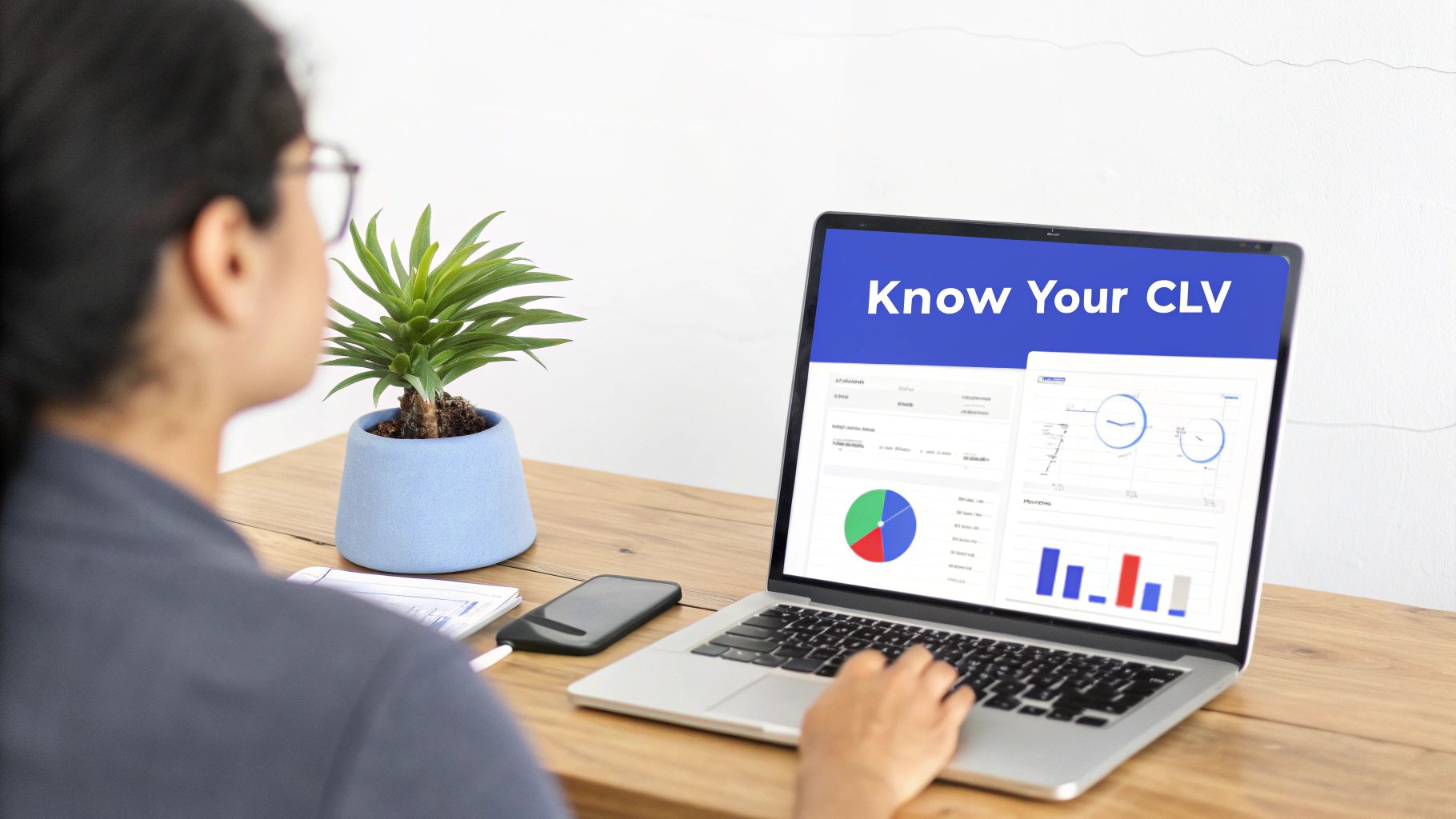 A person views a laptop displaying 'Know Your CLV' dashboard with charts and graphs.