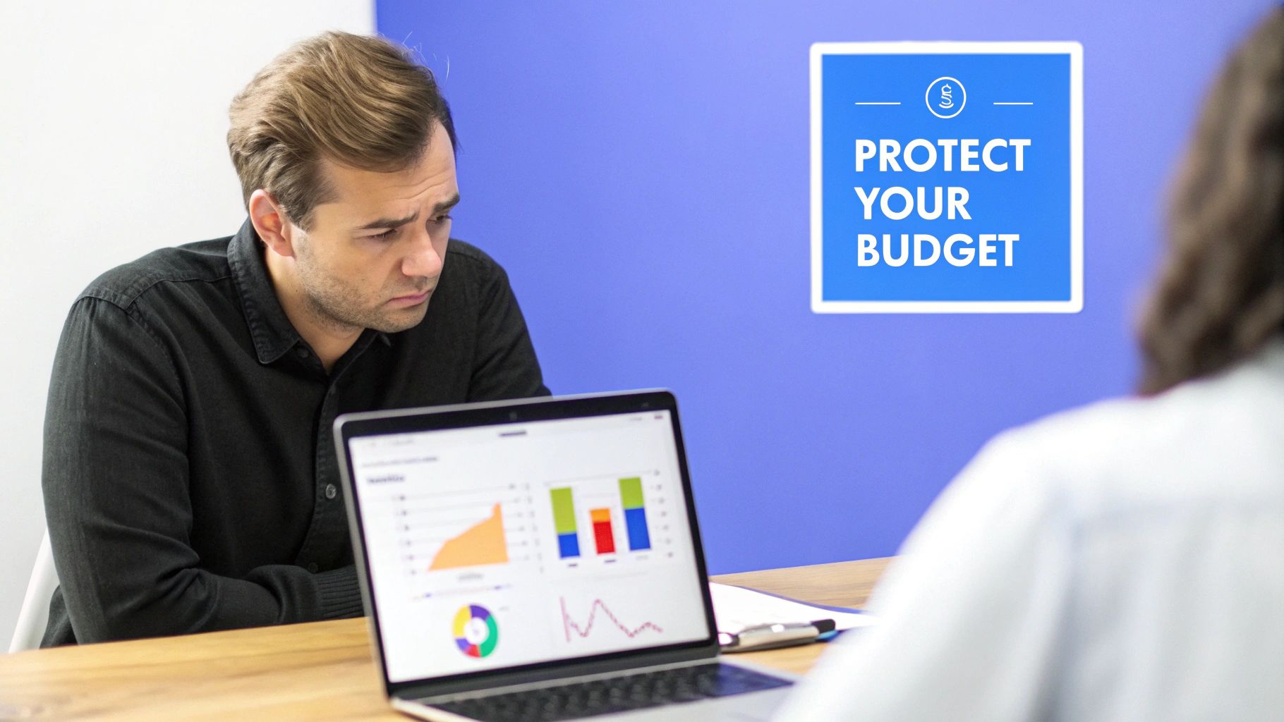 A concerned man examines financial charts on a laptop, with a 'Protect Your Budget' sign in the background.