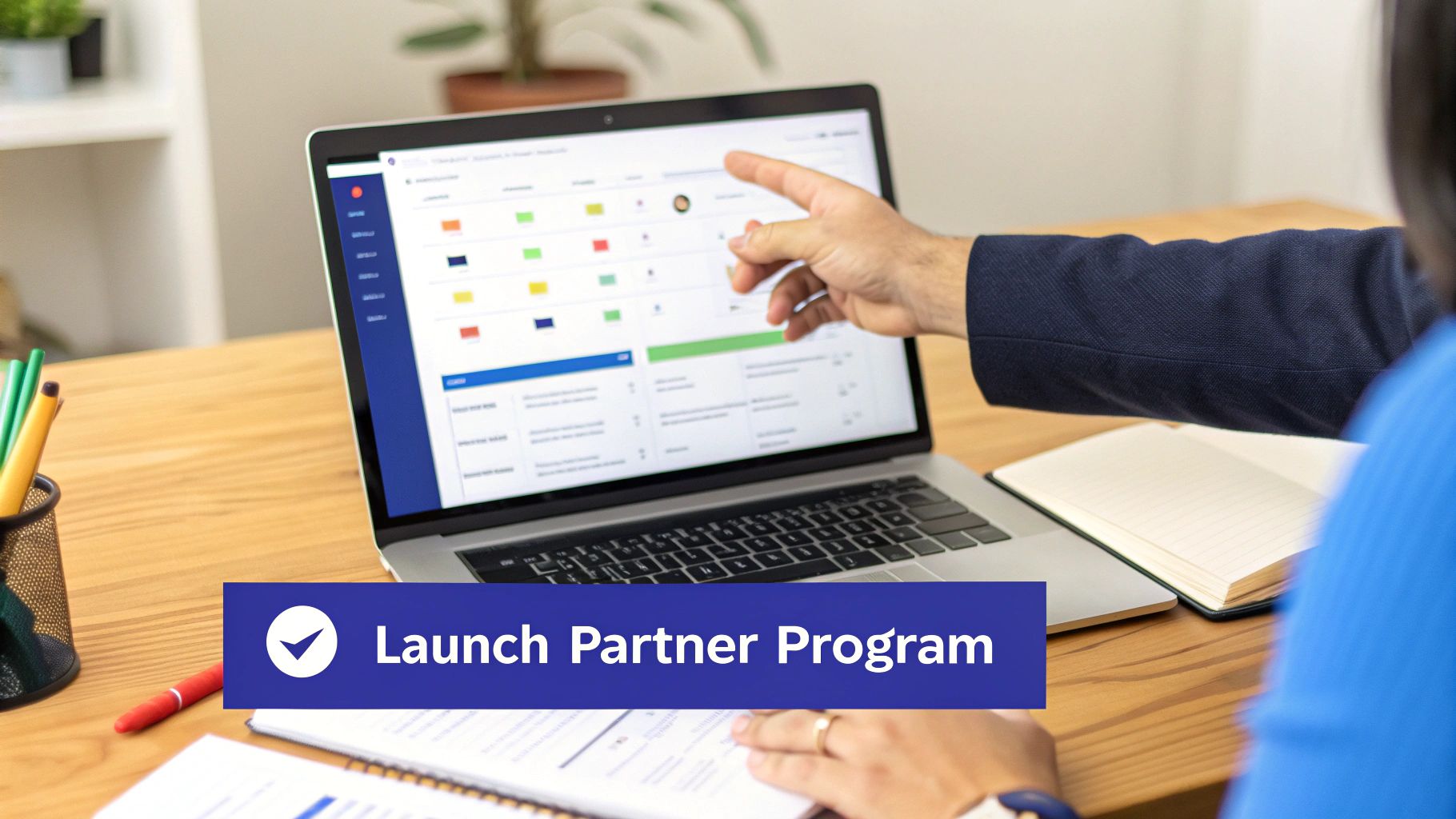 A person points to a laptop displaying a business dashboard, with a 'Launch Partner Program' banner.