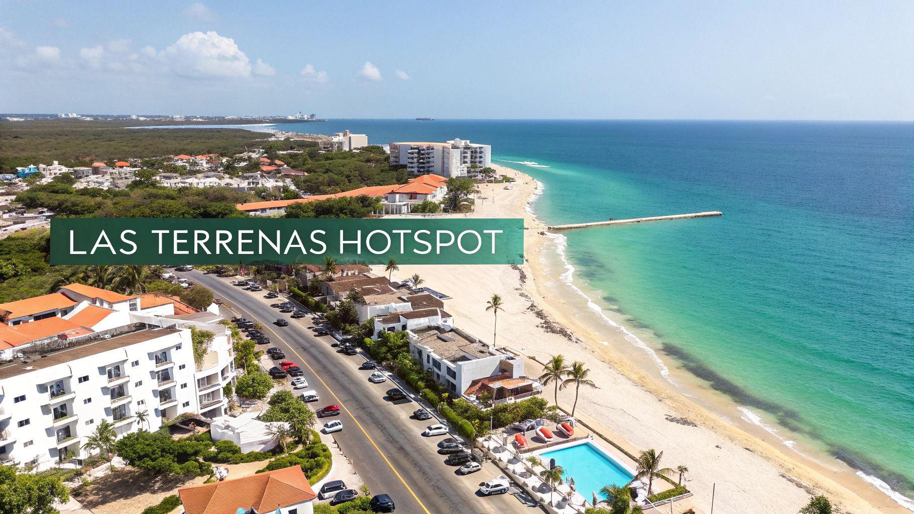 Vista aérea de la costa de Las Terrenas con edificios, carretera, playa de arena y océano turquesa.