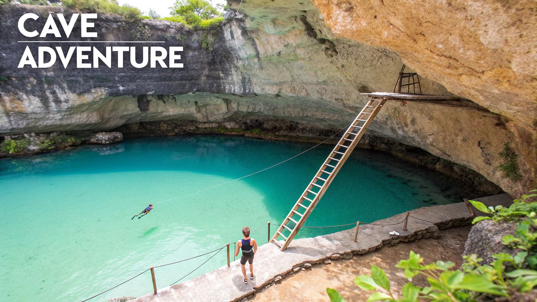 Une personne se tient sur un sentier au bord d'un cénote d'un bleu limpide, à l'intérieur d'une grotte, avec une échelle en bois.