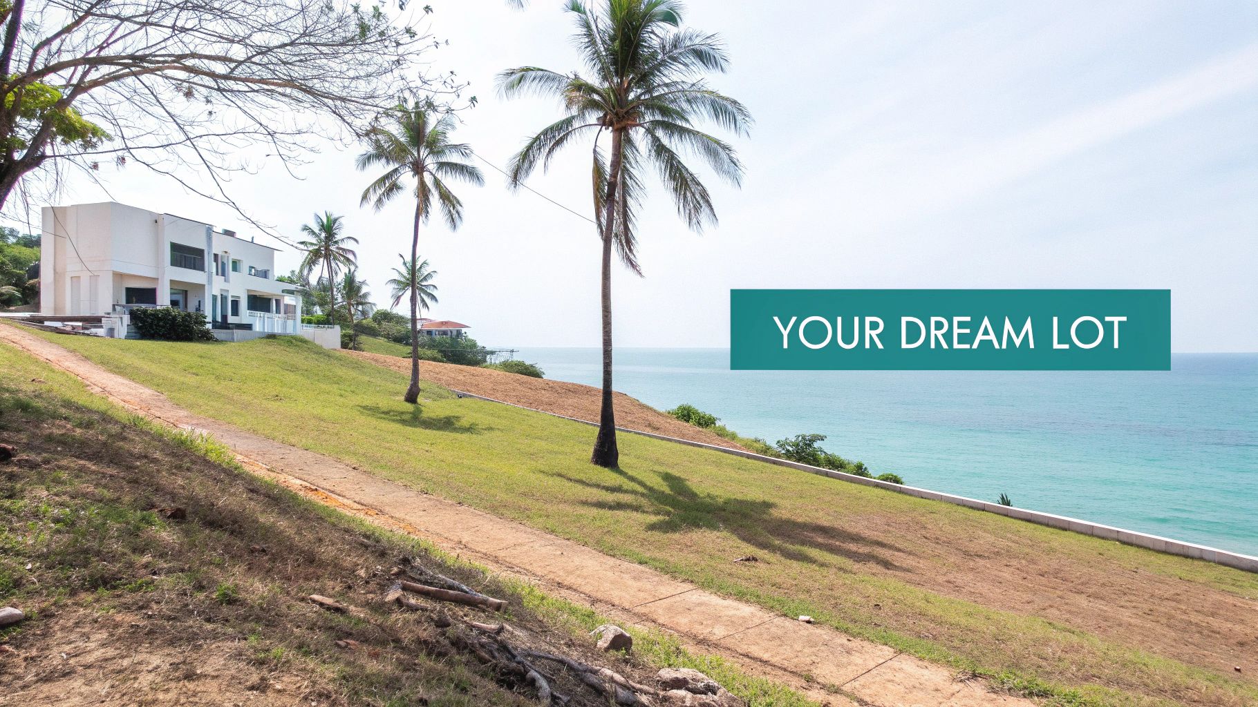 Un pintoresco lote frente al mar con césped verde, palmeras y un edificio moderno con vista al mar turquesa.