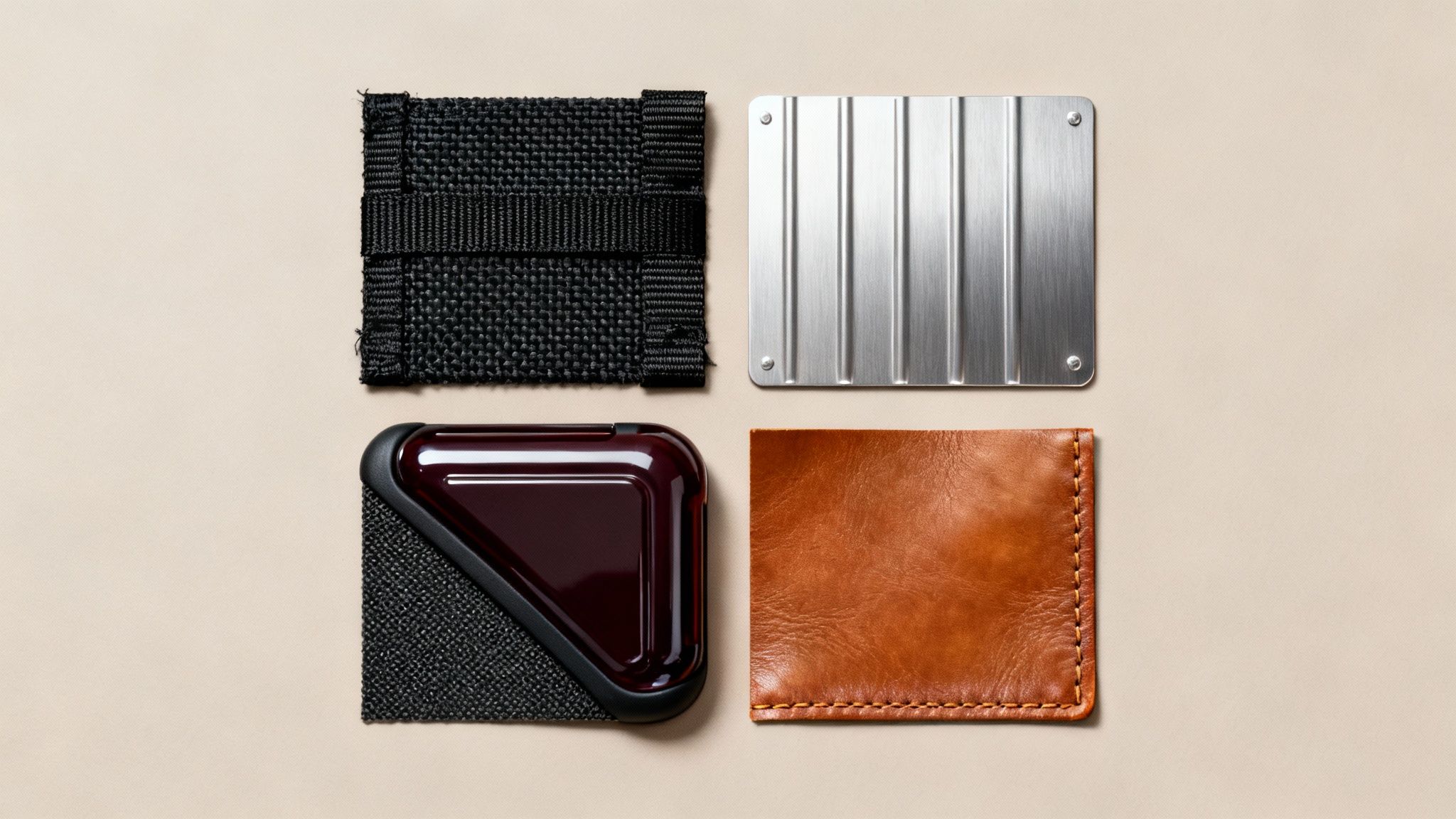 A top-down view of four distinct cardholders or wallets, featuring textile, metal, plastic, and leather.