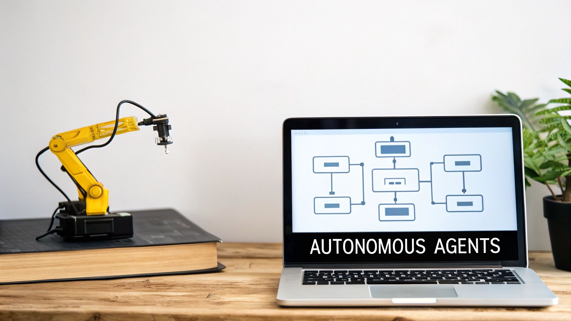 A miniature yellow robotic arm next to a laptop displaying an 'Autonomous Agents' flowchart.
