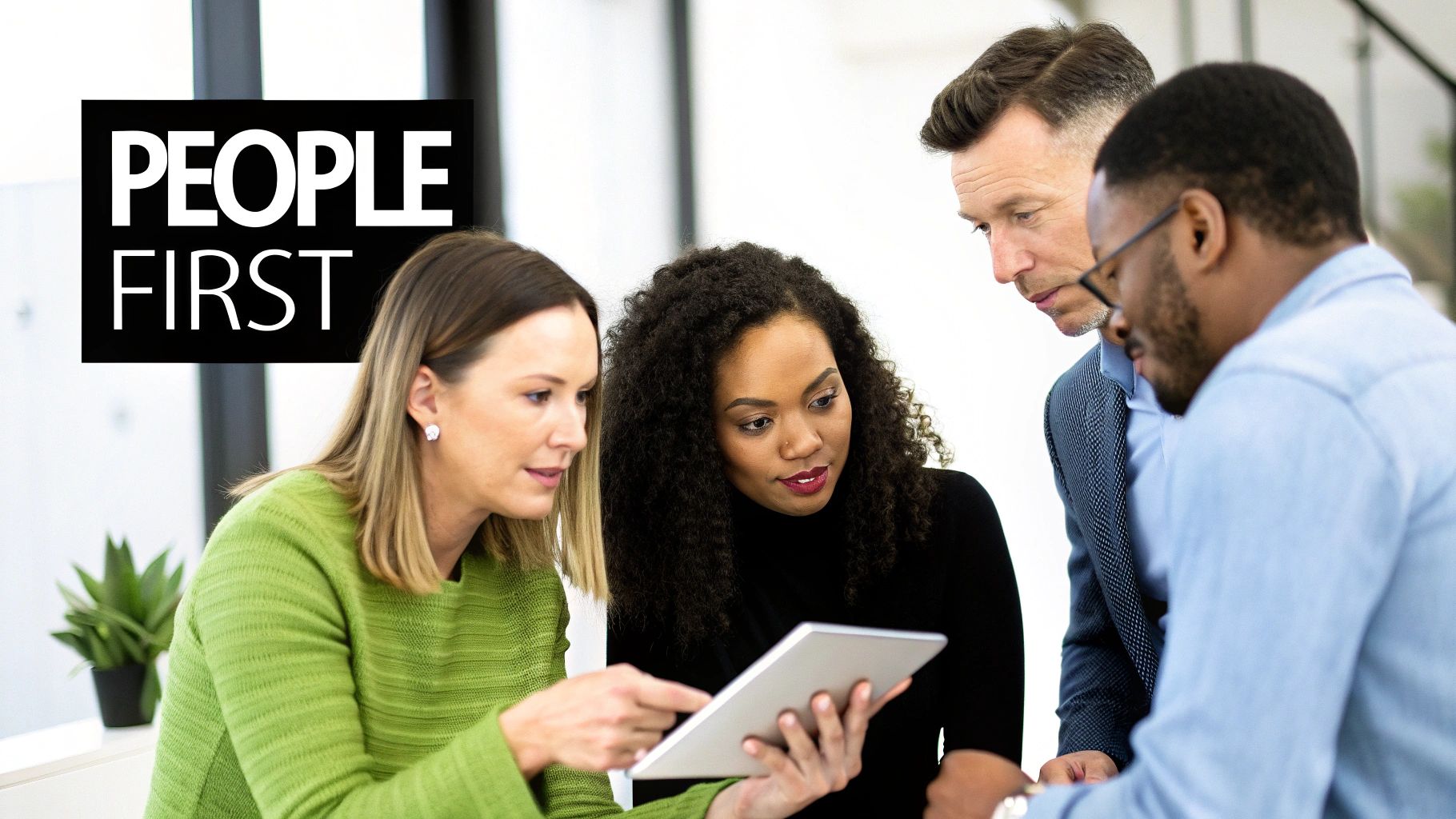 Diverse professionals collaborate, looking at a tablet in an office, with 'PEOPLE FIRST' text overlay.