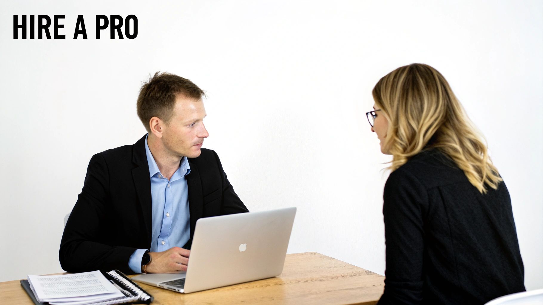 A tax professional discusses documents with a client in a well-lit office.