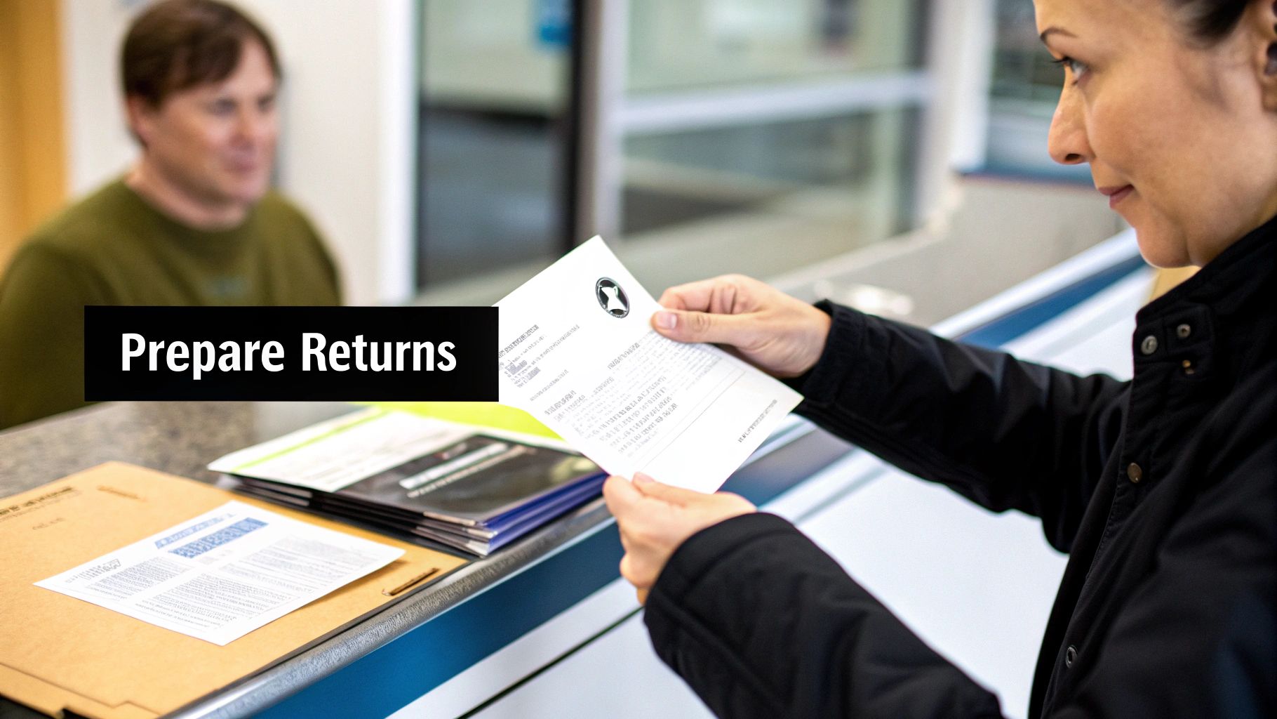 A woman in a black jacket holds a document, preparing tax returns at a counter.