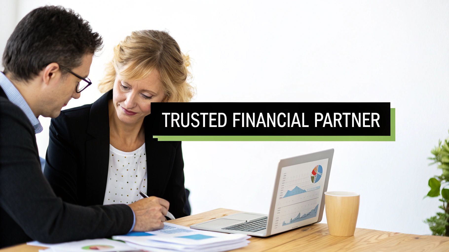 Two financial professionals collaborating, reviewing documents and discussing data on a laptop, signifying a trusted partnership.