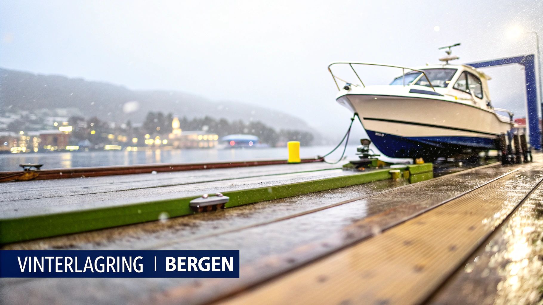En hvit båt står på en kai i Bergen under lett snøfall, klar for vinterlagring.