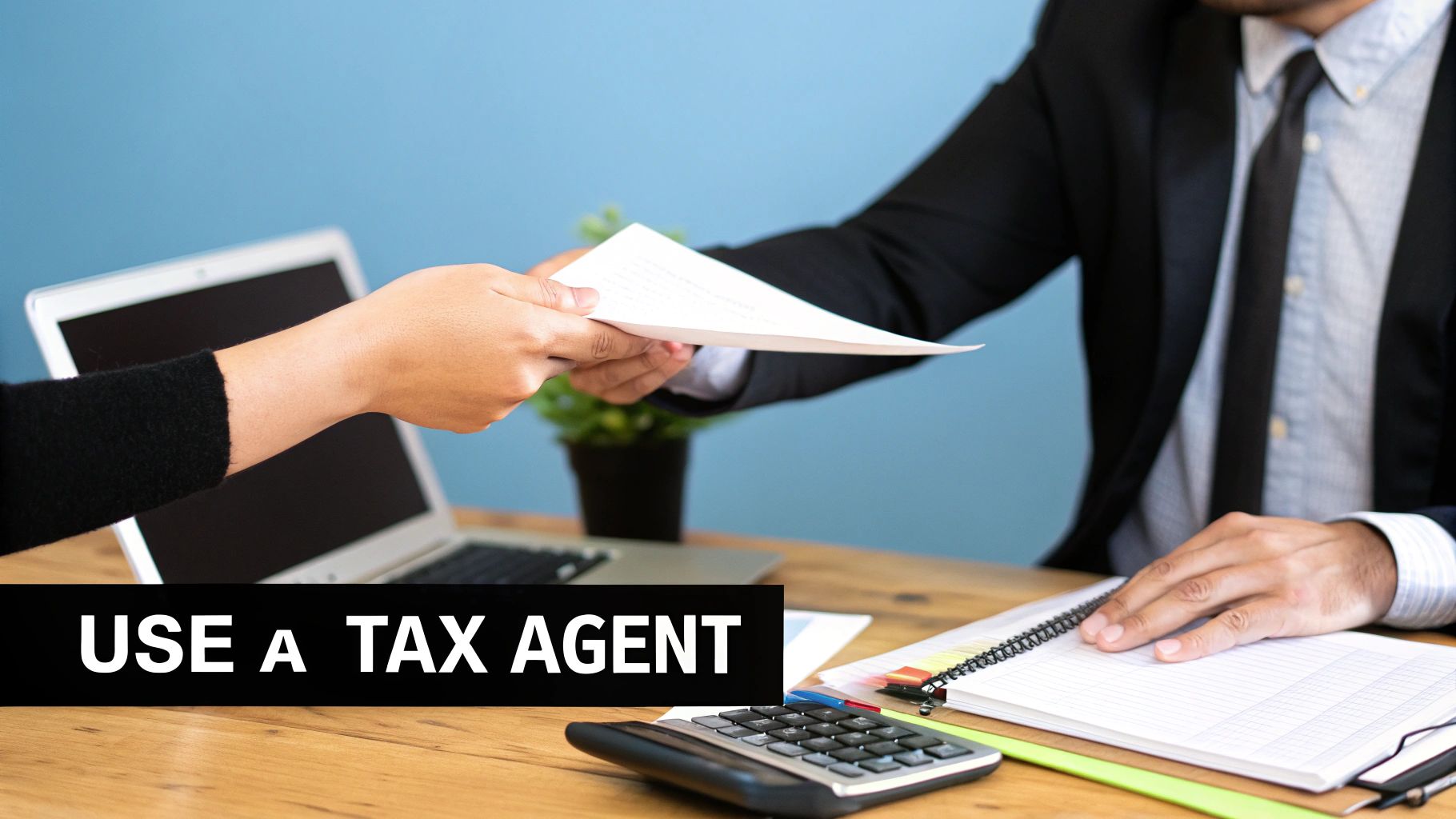 Two people exchanging financial documents on a desk with a laptop and calculator, promoting a tax agent.
