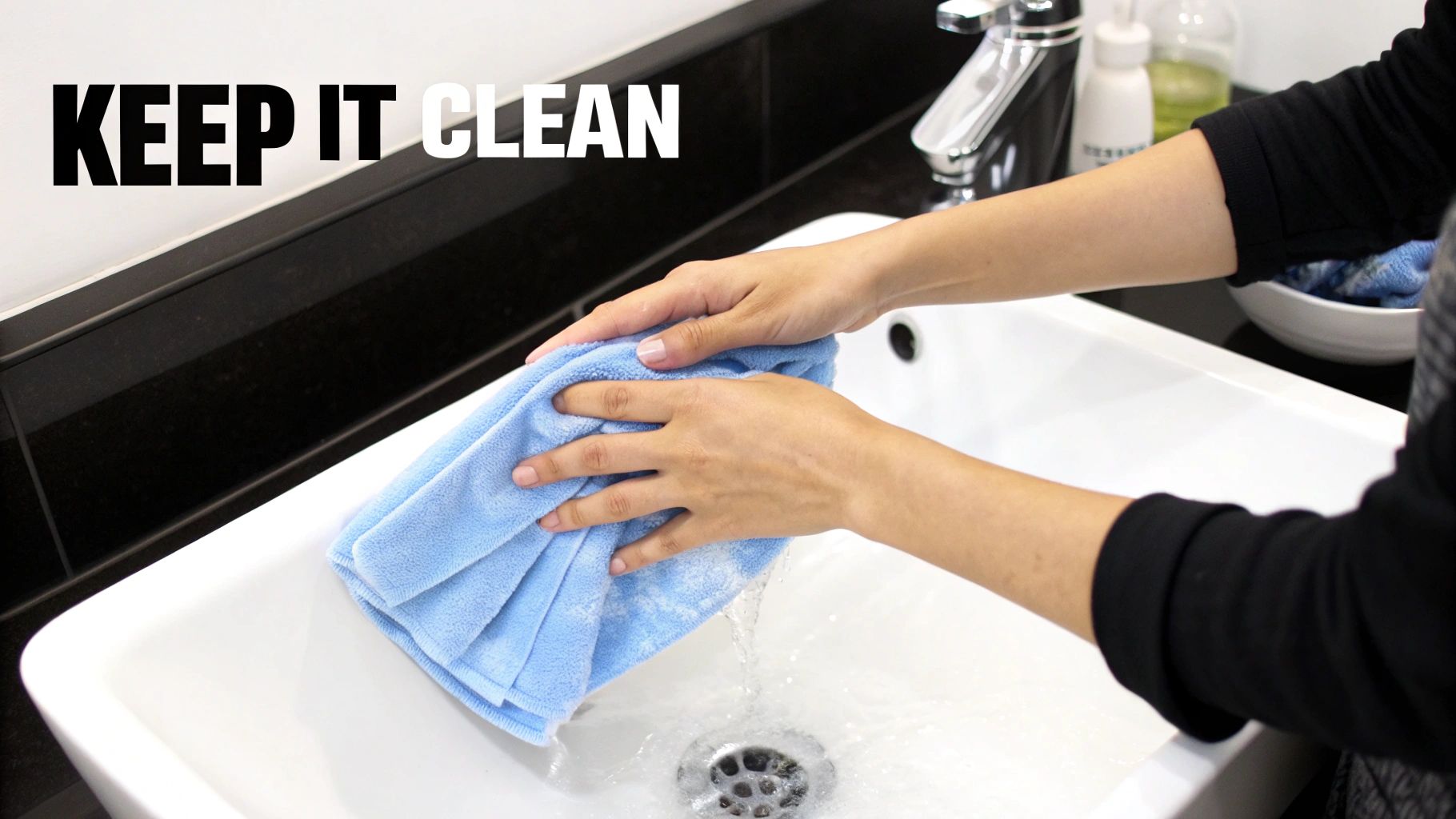 Hands washing a blue microfiber cloth under running water in a white sink.