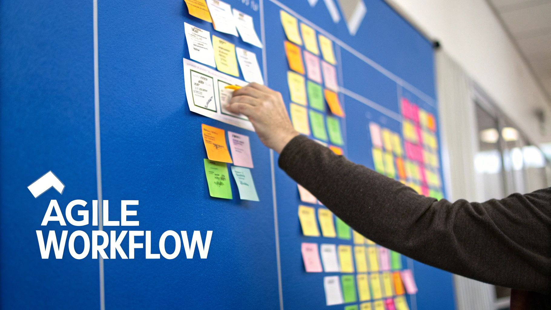 A team collaborates around a desk with laptops and sticky notes, showing an agile and dynamic workflow.