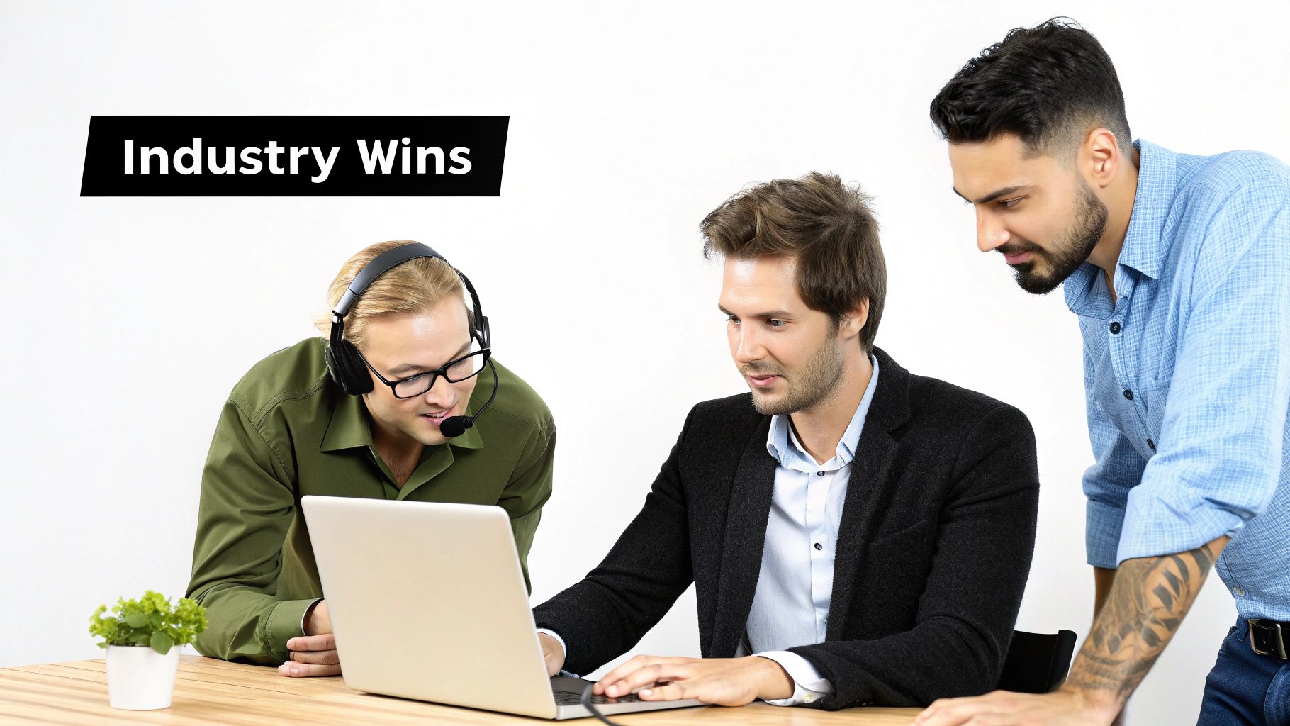 Three male professionals collaborating on a laptop, one wearing a headset, in an office environment.
