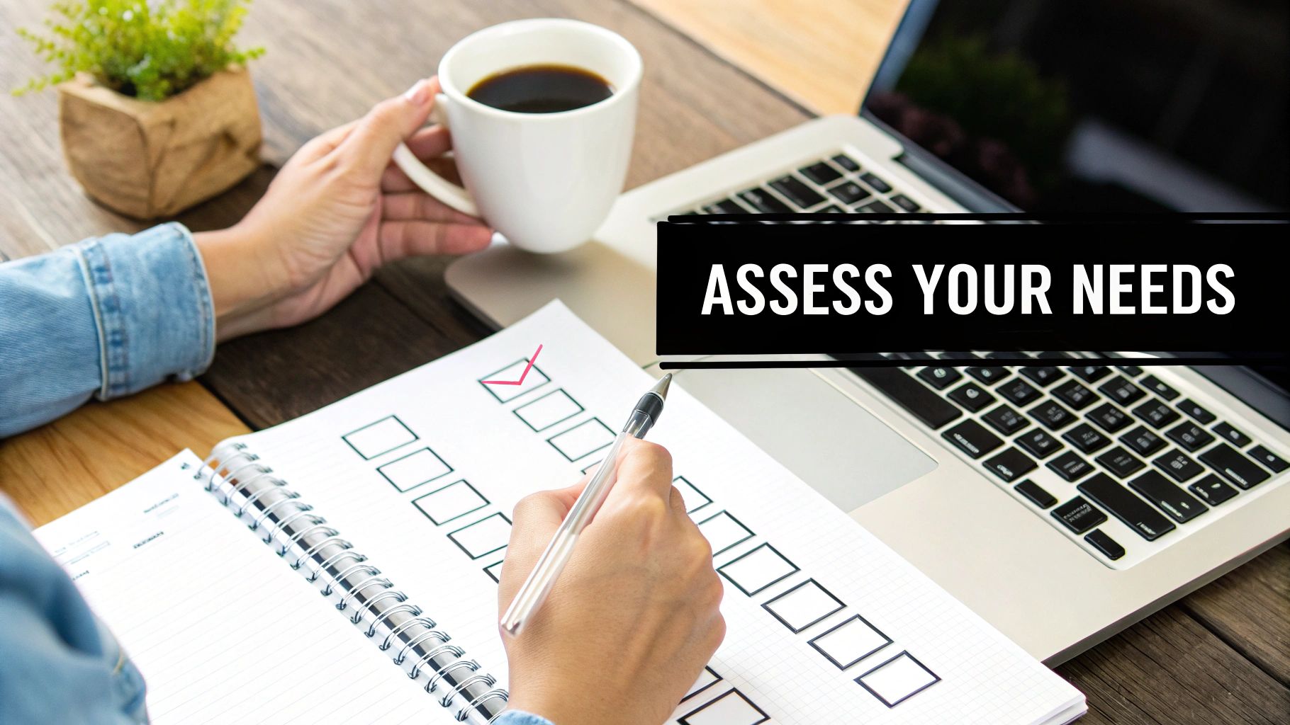 Person marking a checklist with a pen, holding coffee, beside a laptop, with 'ASSESS YOUR NEEDS' text.