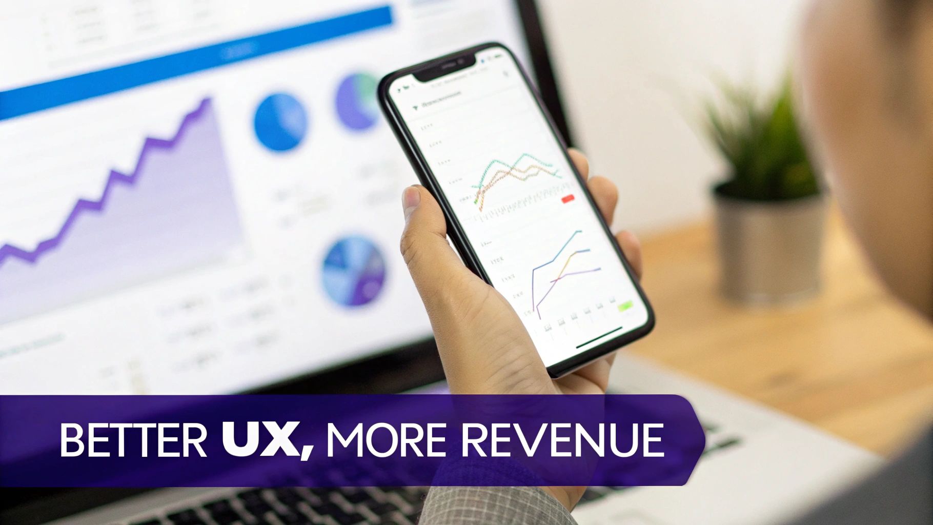 A hand holds a smartphone displaying data analytics charts, with a laptop showing more graphs in the background, implying business growth and UX.