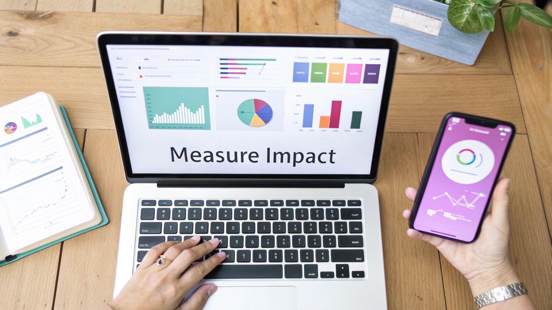 Person's hands typing on a laptop and holding a smartphone, both displaying data analysis charts.