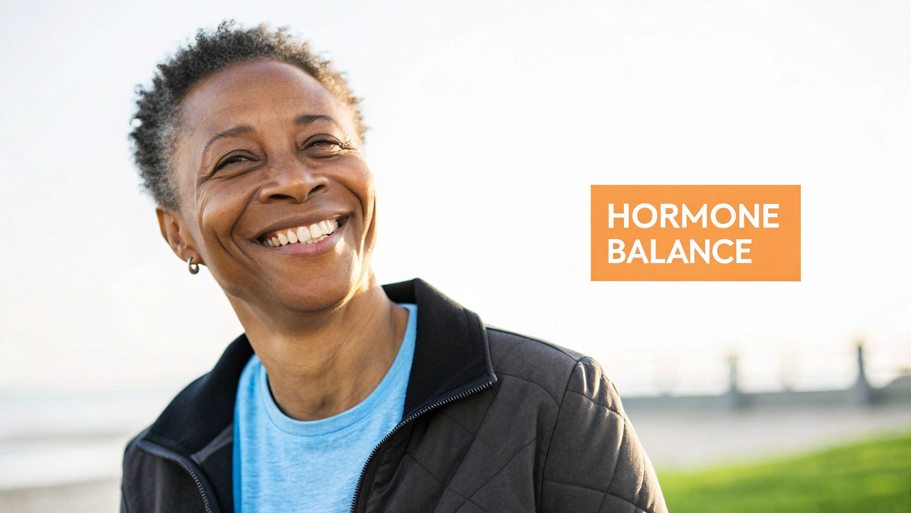 A smiling older Black woman with short hair looking happy outdoors, with 'HORMONE BALANCE' text.