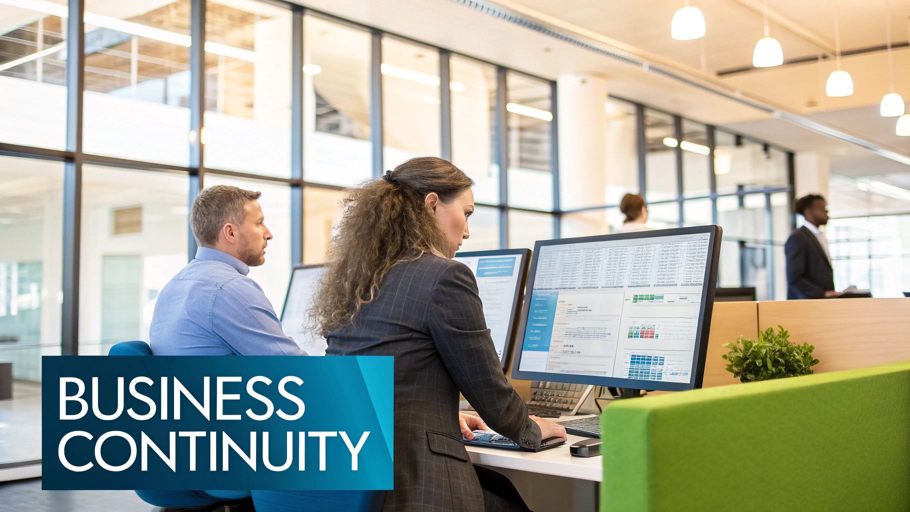 A person working at a desk with multiple computer screens displaying data and graphs.