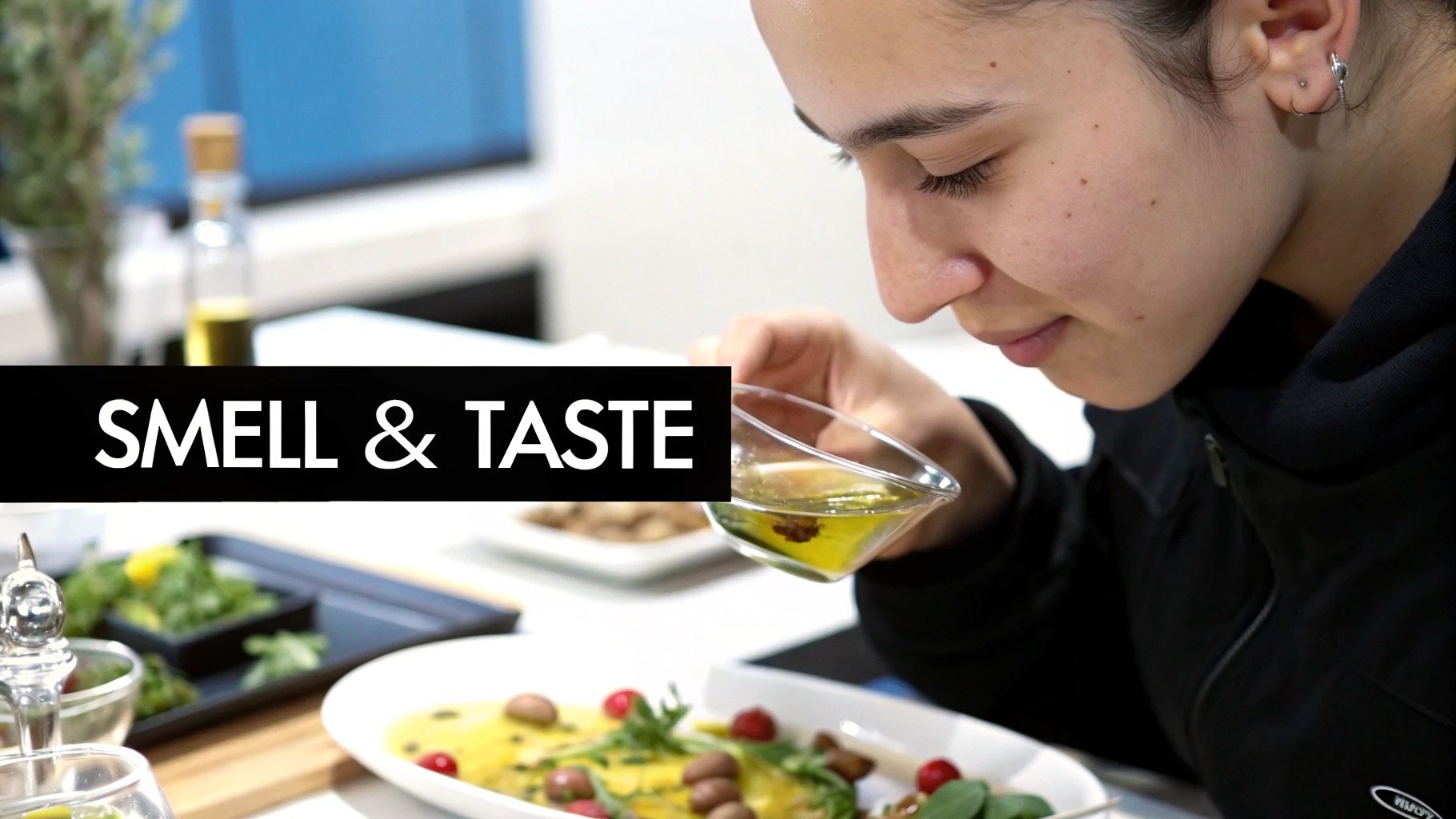 A person pouring olive oil into a small tasting glass.