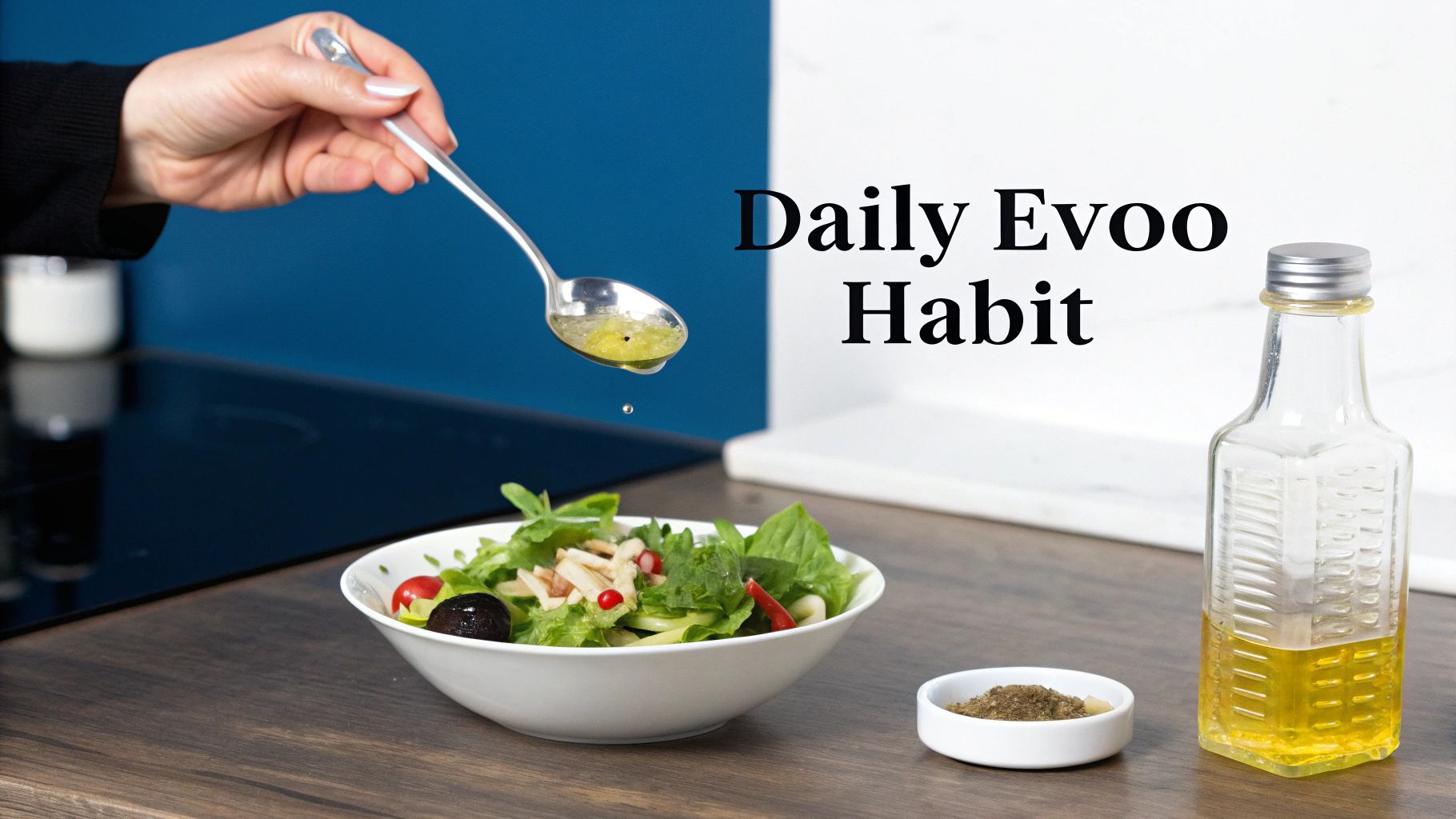 Hand pouring olive oil dressing from a spoon onto a fresh salad bowl, with an EVOO bottle nearby in a kitchen.