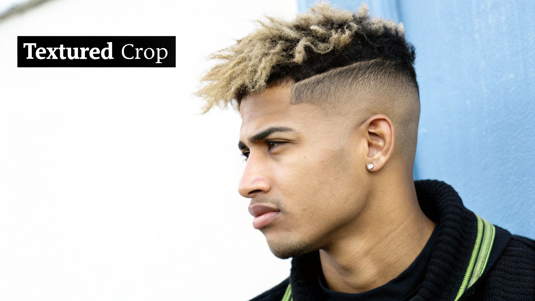 A young man with a textured crop haircut and a faded undercut, looking to the side.