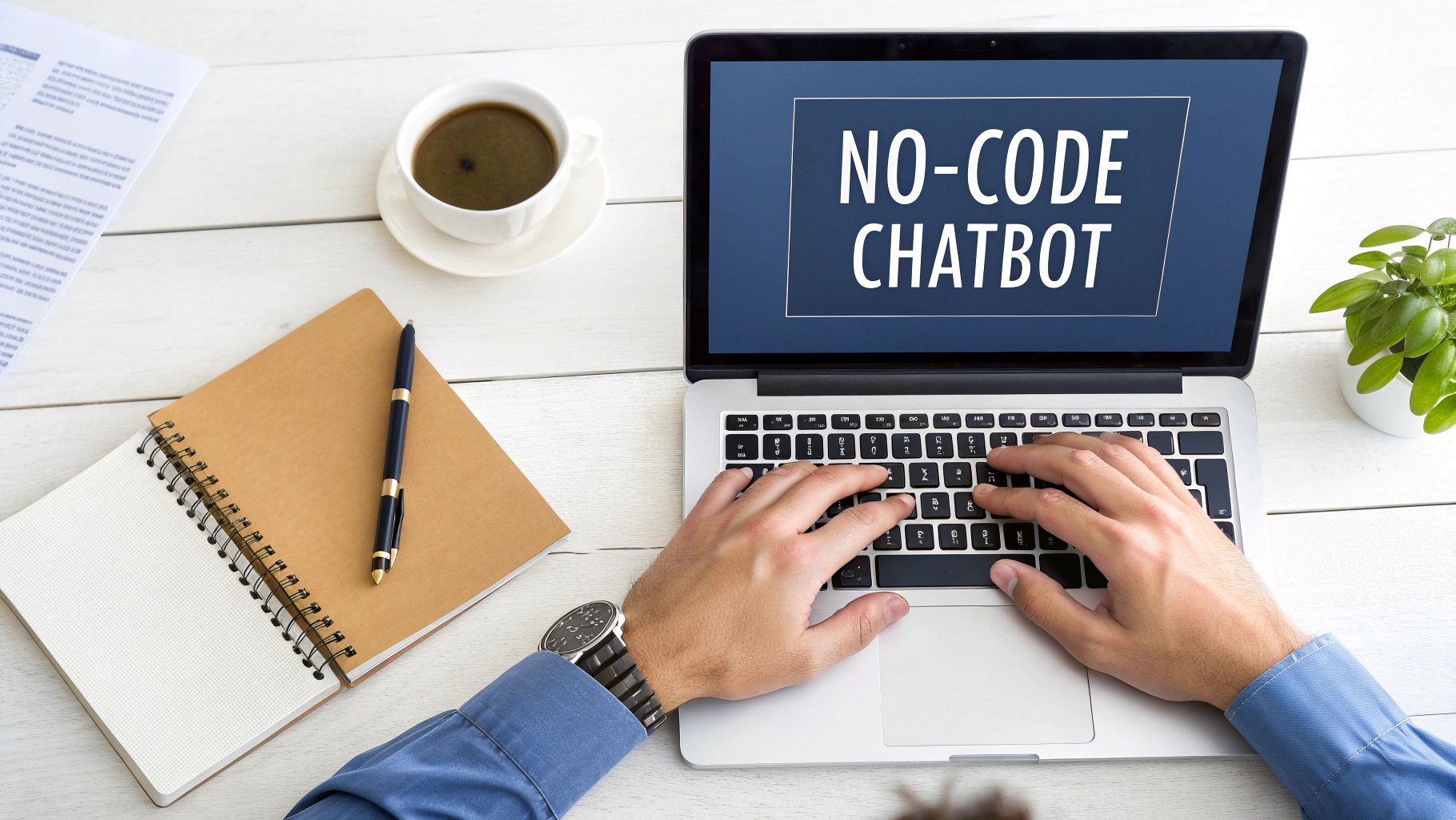 Overhead view of a person typing on a laptop with 'NO-CODE CHATBOT' on screen, coffee, and notebook.