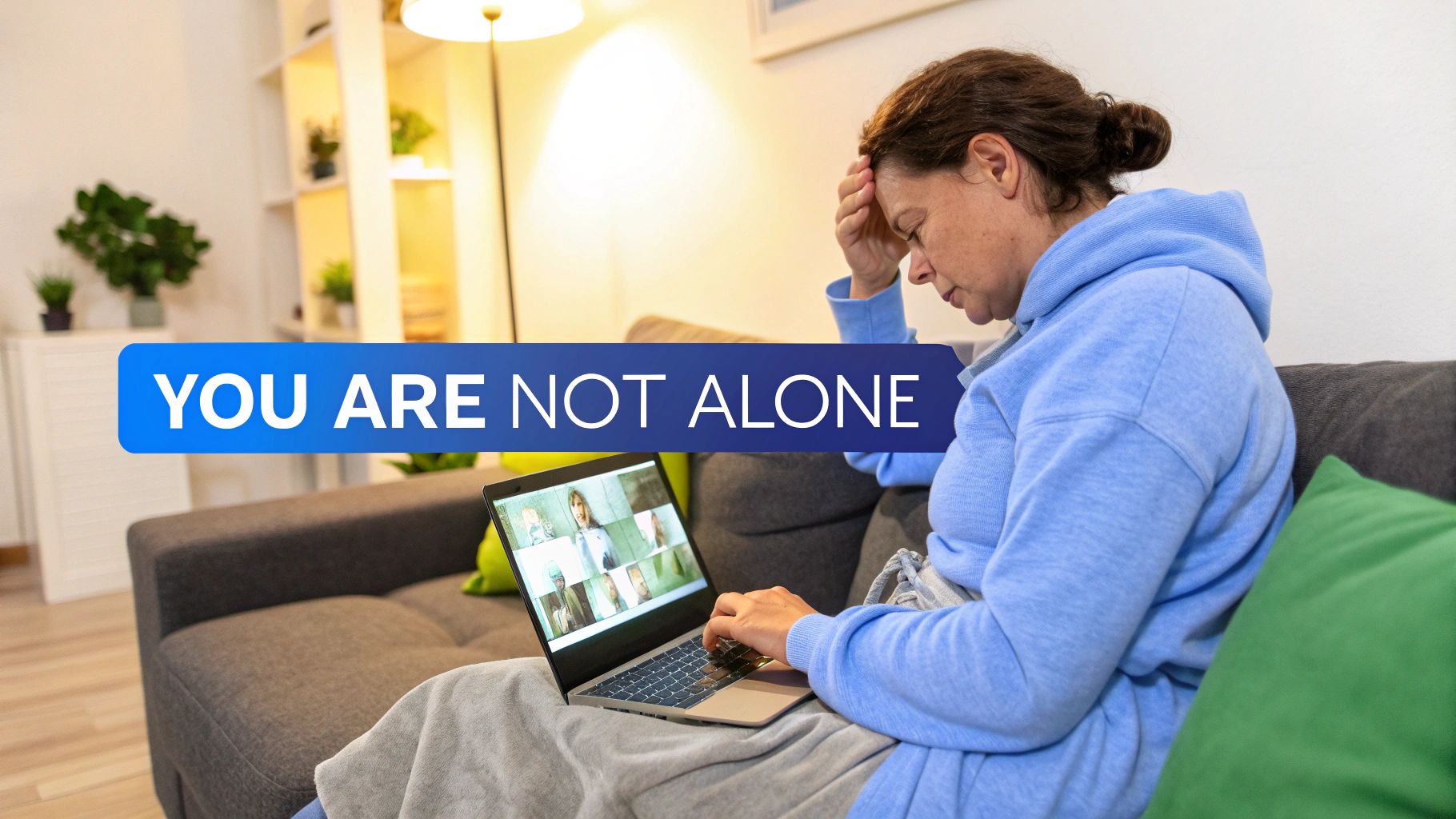 A caregiver and an elderly person smiling together on a couch.