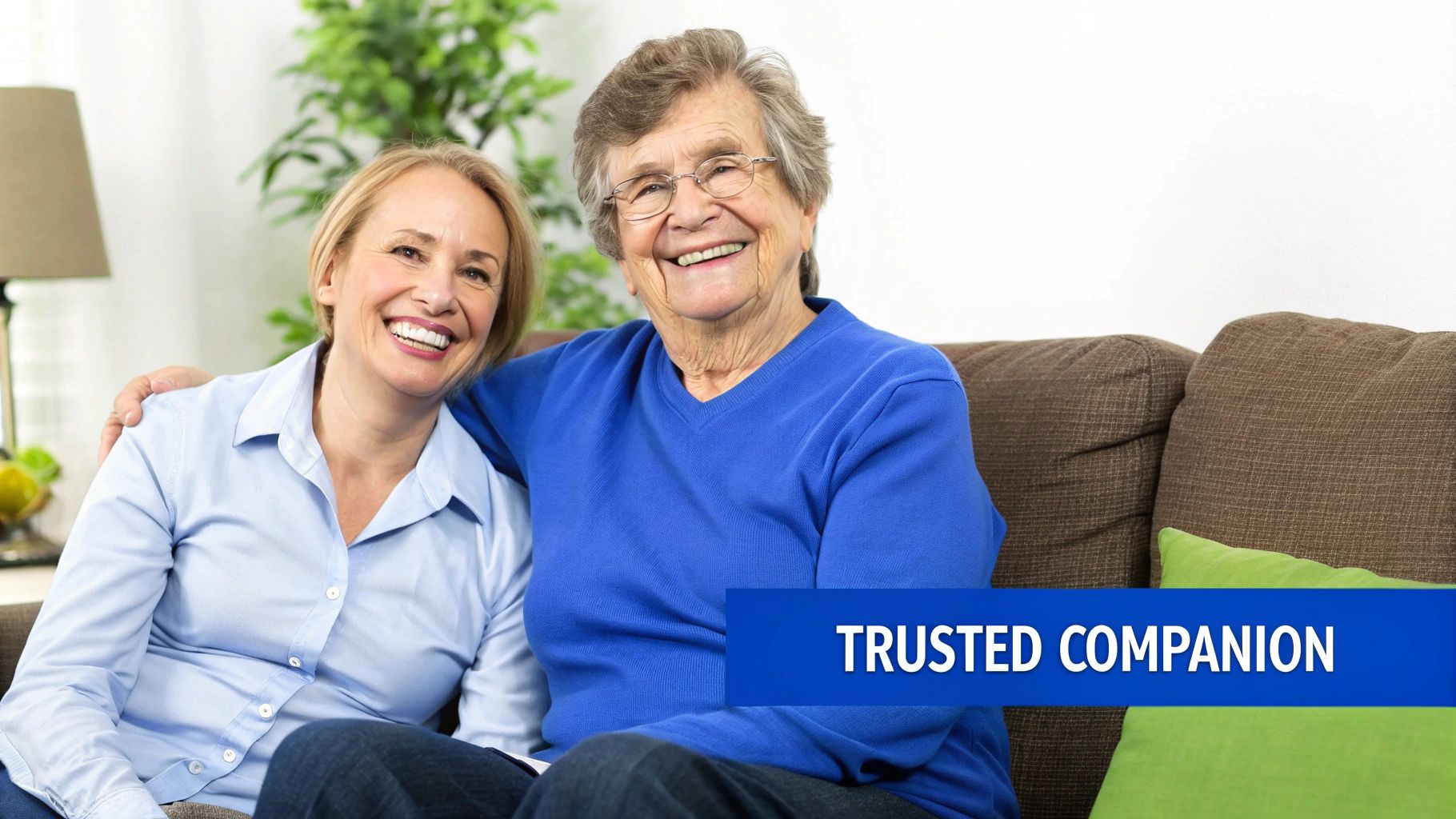 A smiling young woman and an elderly woman sit together on a couch, representing trusted companionship.
