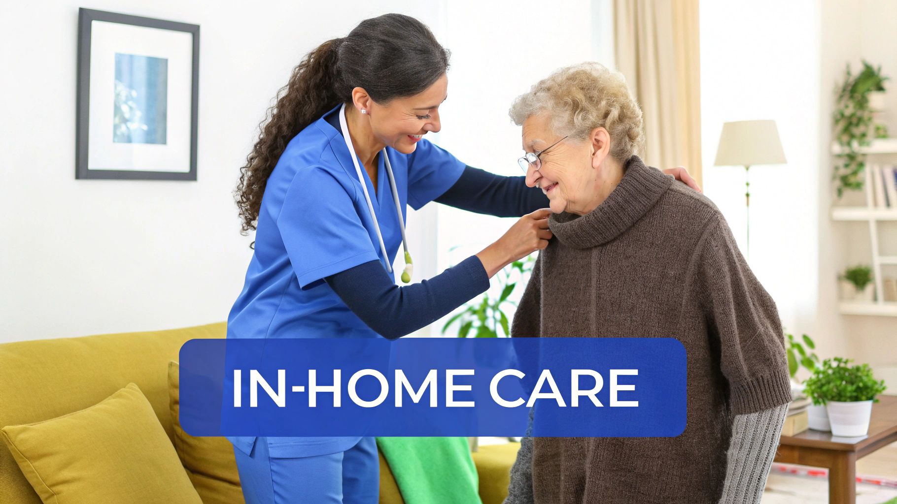A smiling caregiver in blue scrubs helps an elderly woman with glasses in a bright home setting.