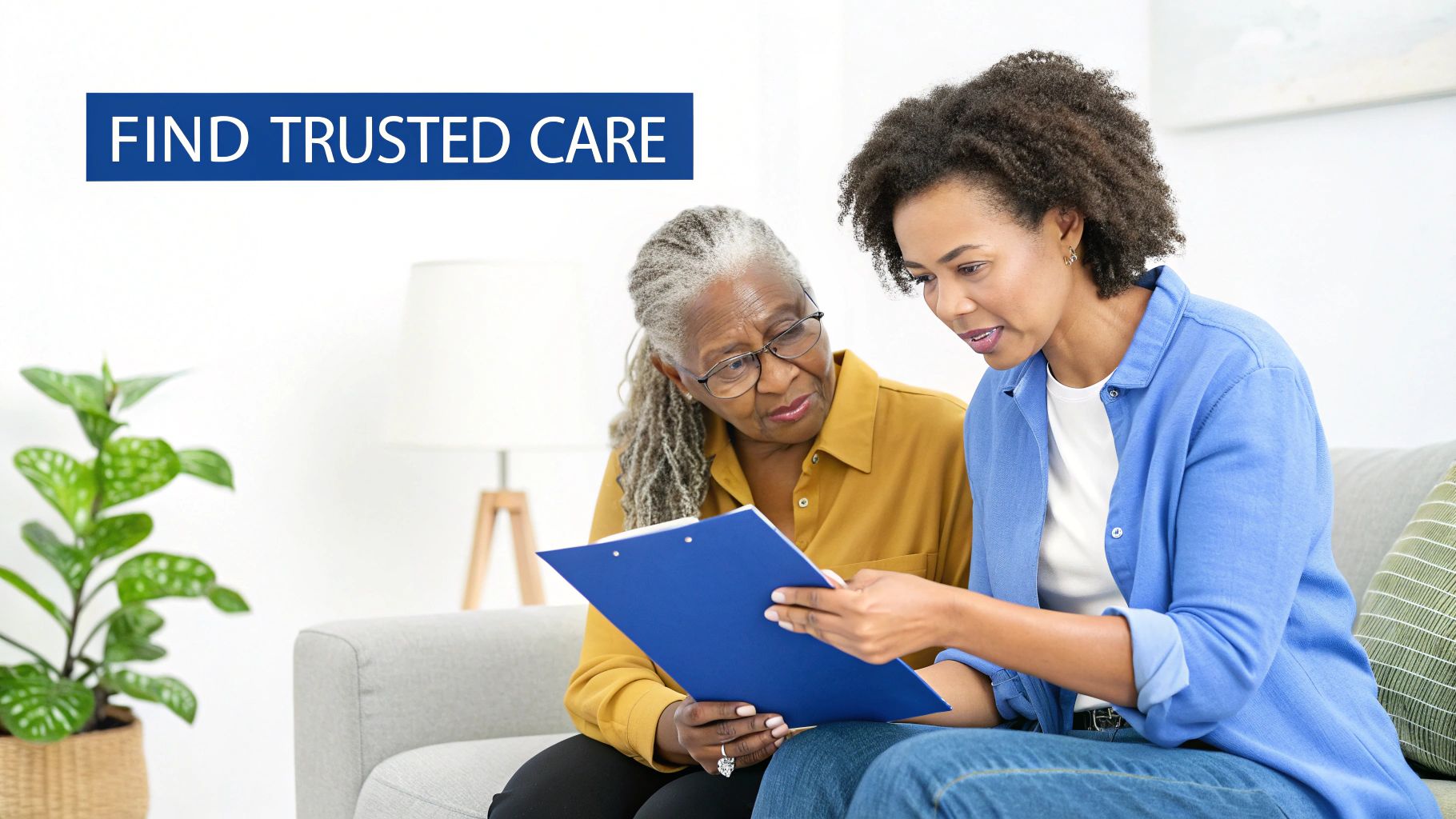 A young woman explains information on a blue clipboard to an older woman with glasses on a couch.