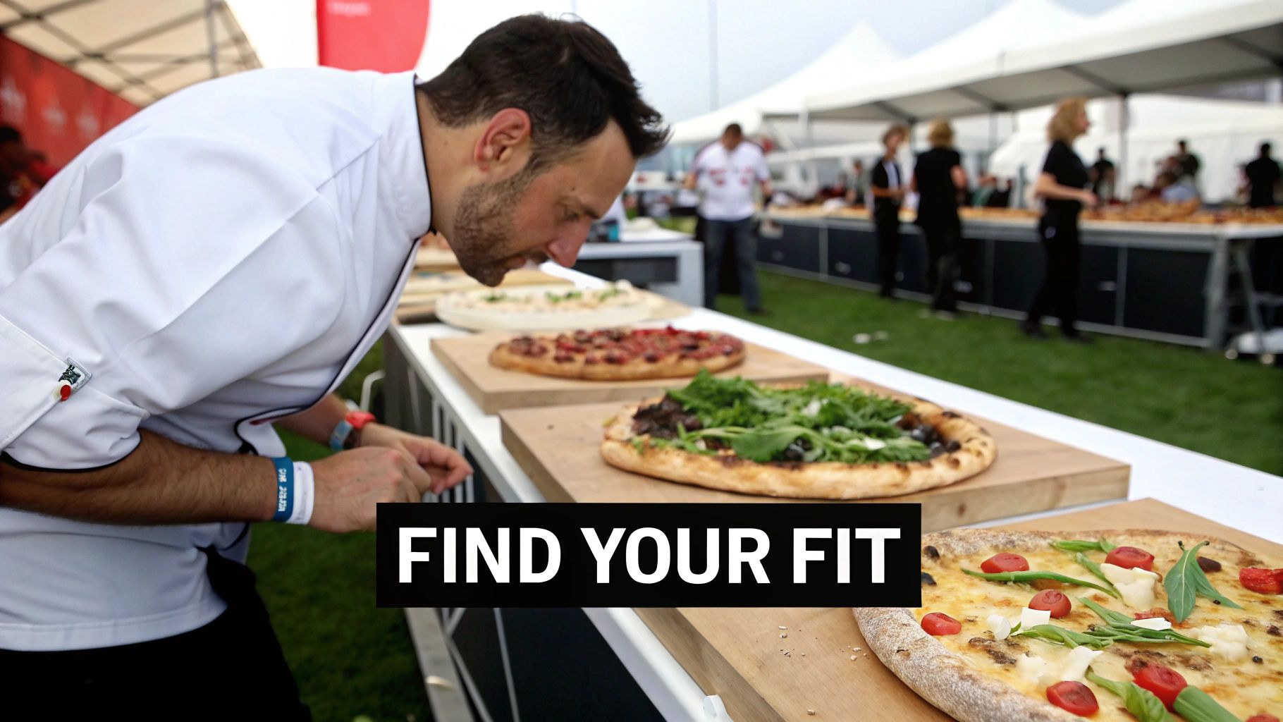 A person selecting various pizza toppings from a well-organized commercial prep table.