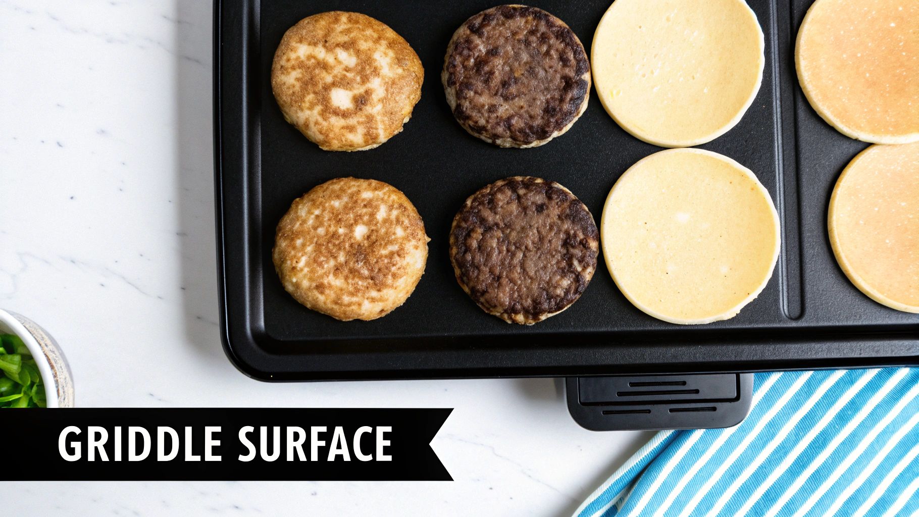 Sausage patties and pancakes cooking on a black electric griddle, ready for breakfast.