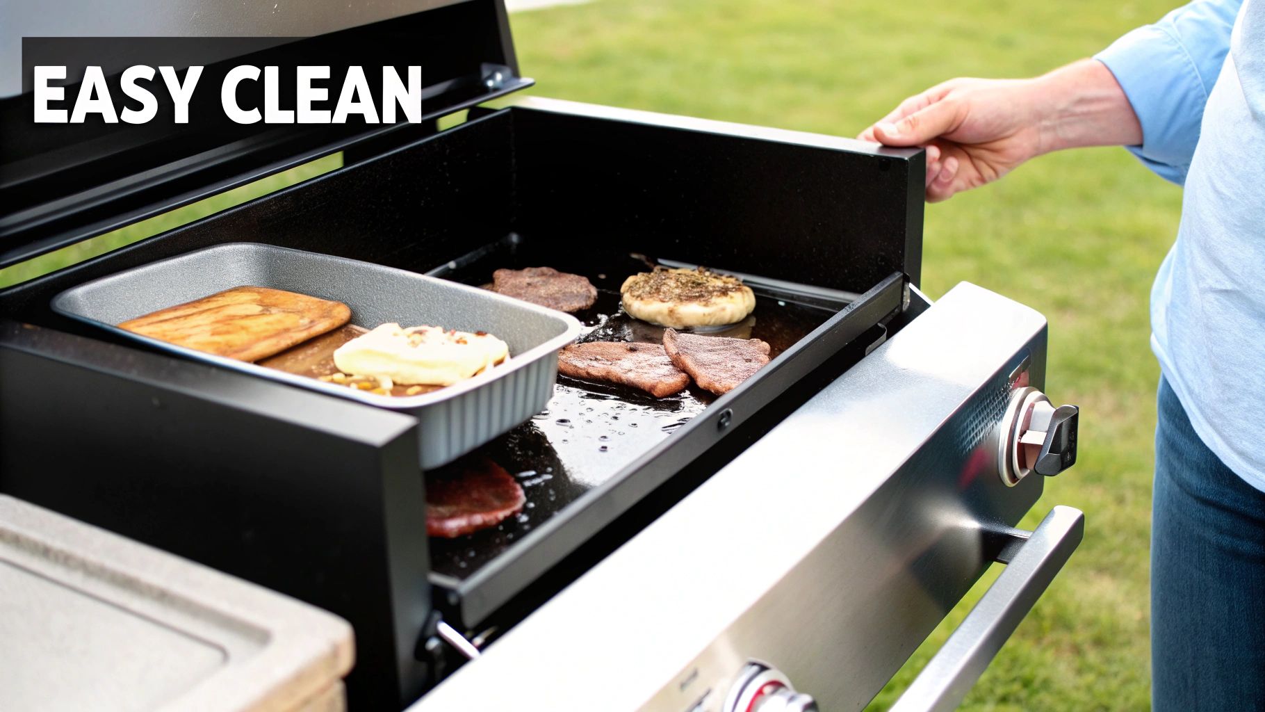 A commercial kitchen worker easily wiping down a clean stainless steel electric griddle after service.