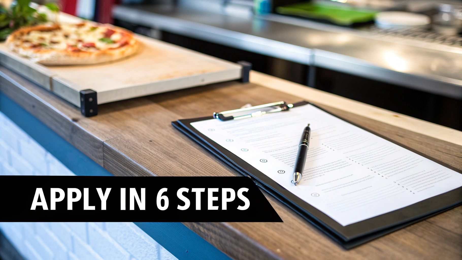 A person signing financing documents for a pizza prep table in a modern pizzeria setting.