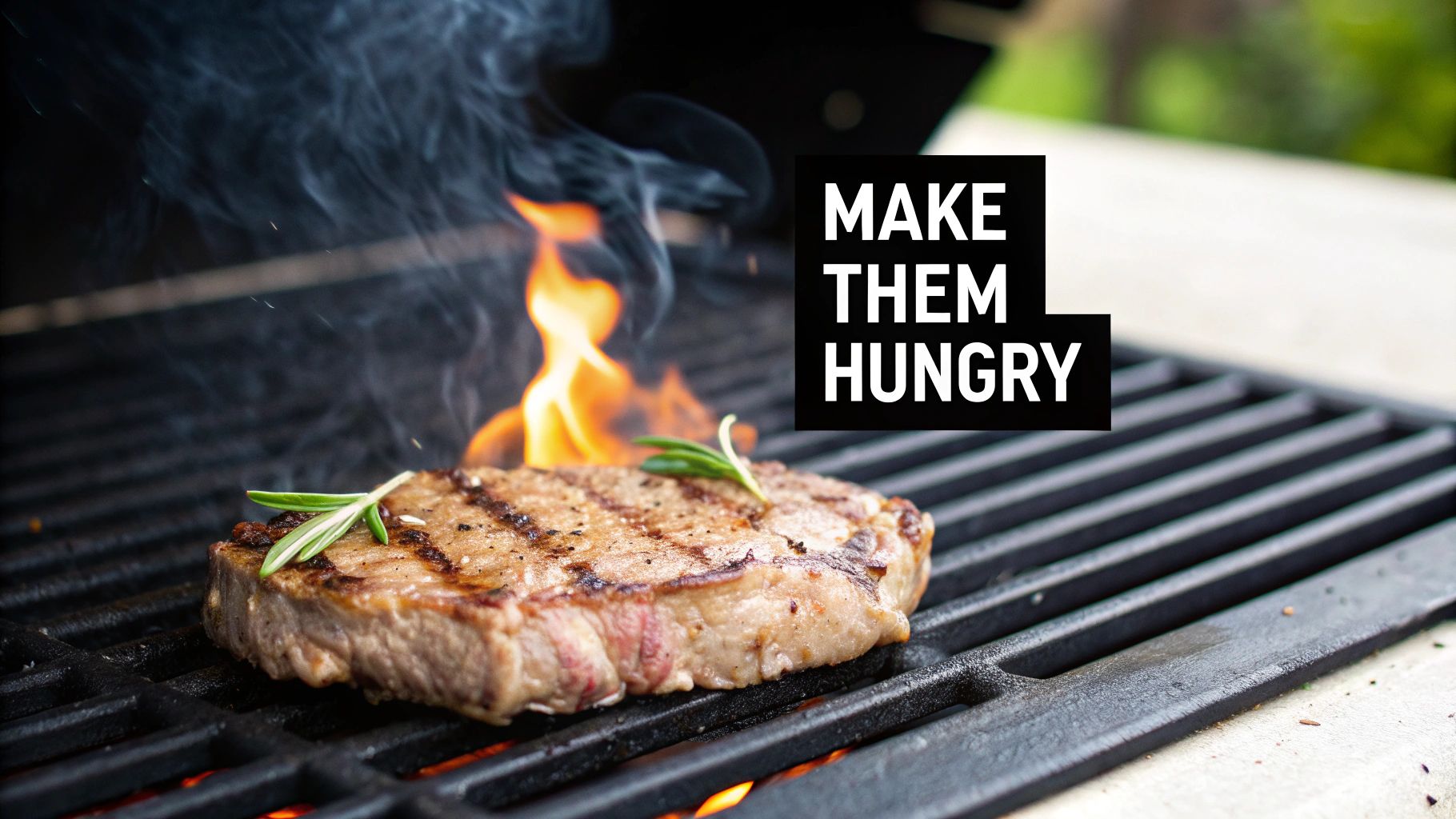 A delicious steak with rosemary grilling on a barbecue with flames and smoke.