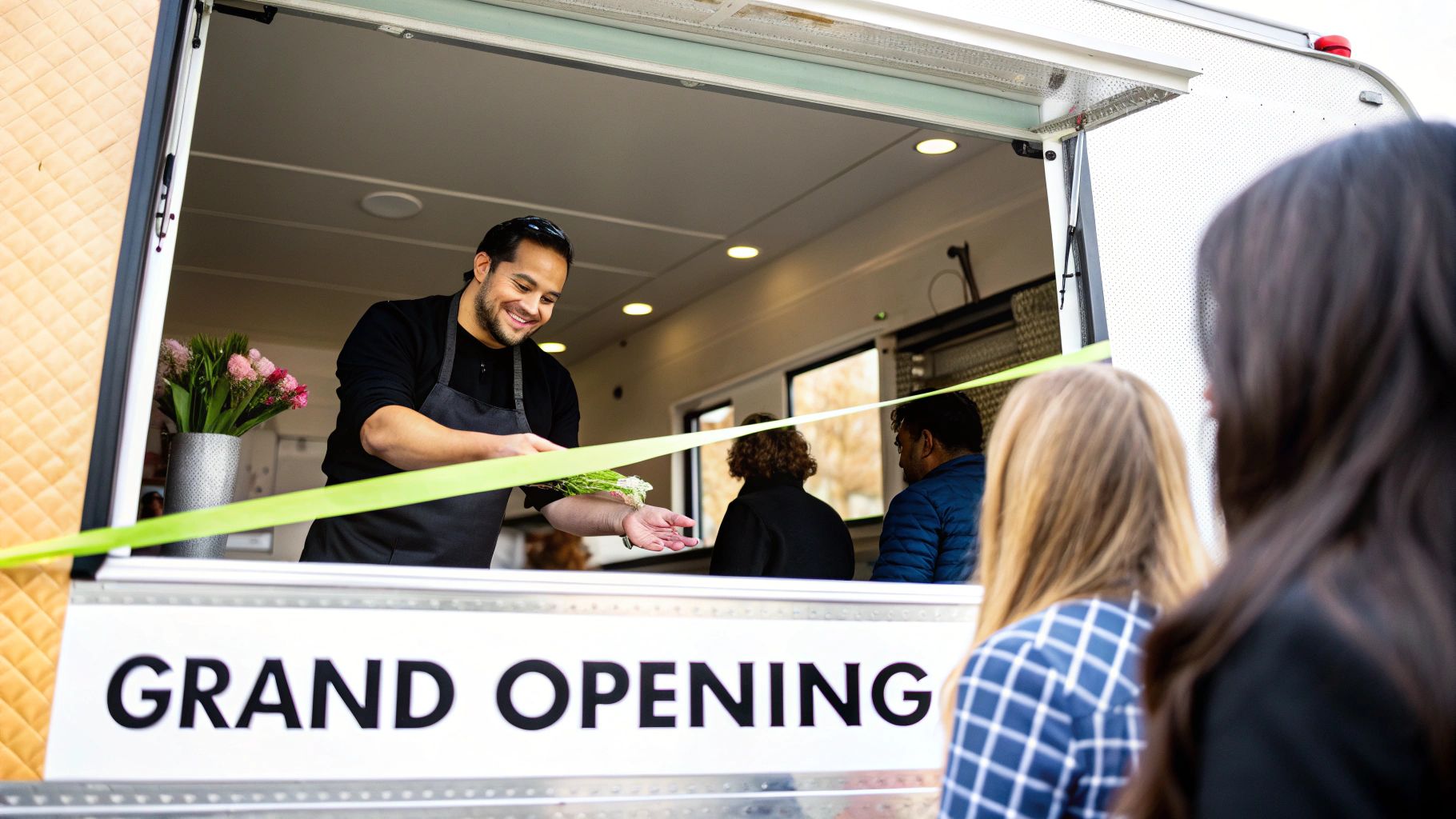 A happy food truck owner standing proudly in front of their vehicle, symbolizing ownership.