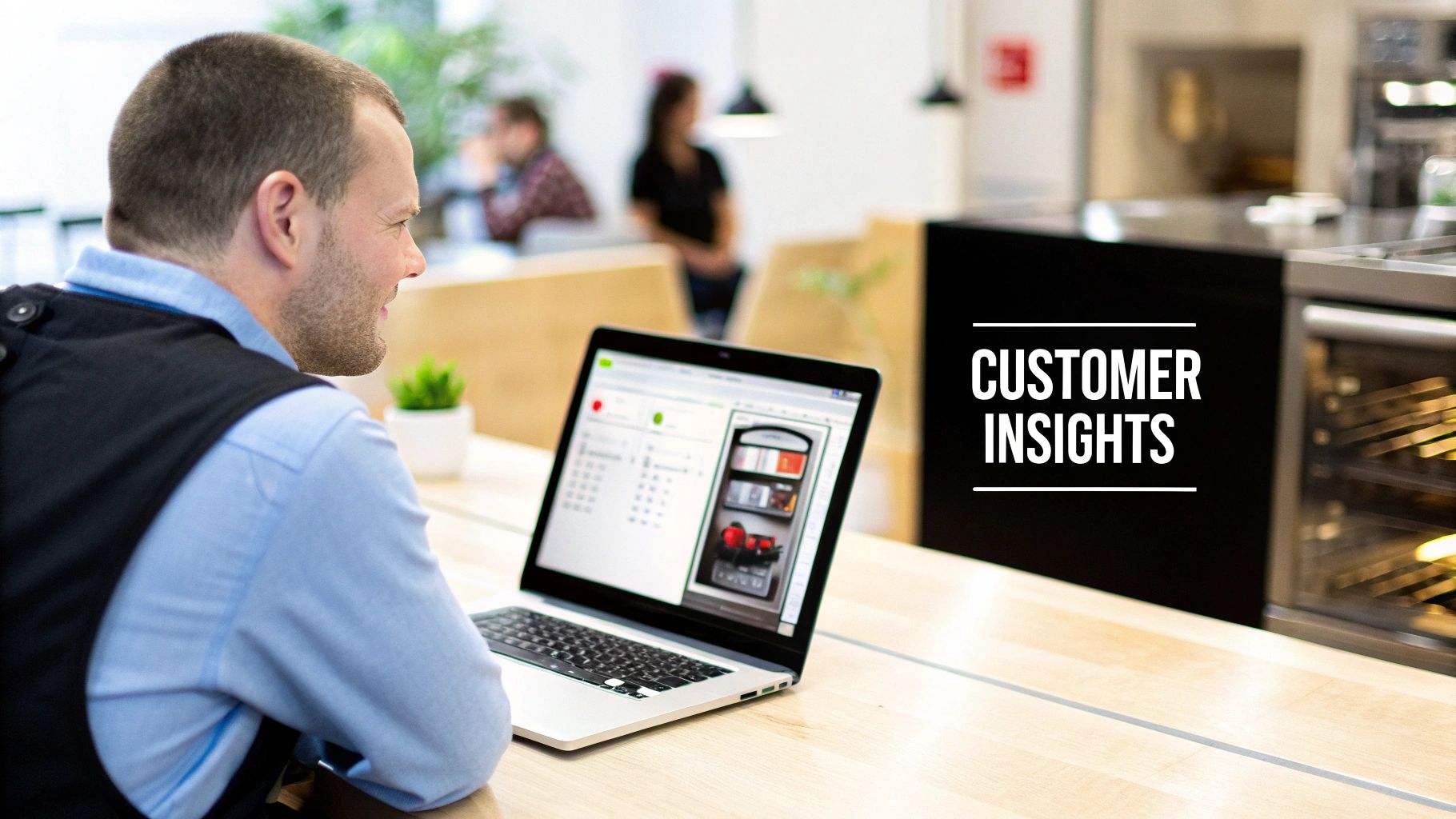 Professional man using a laptop to analyze customer insights in a bright office environment.