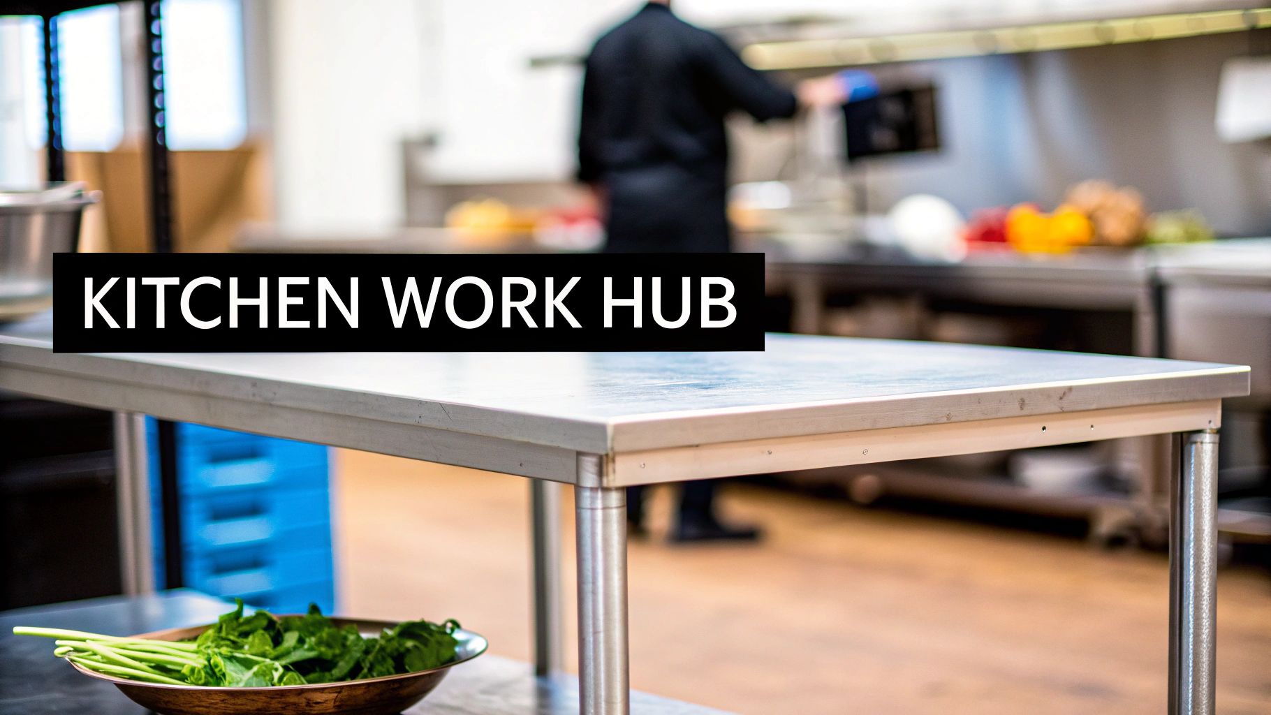 A stainless steel kitchen work table with fresh green vegetables, blurred chef working in the background.